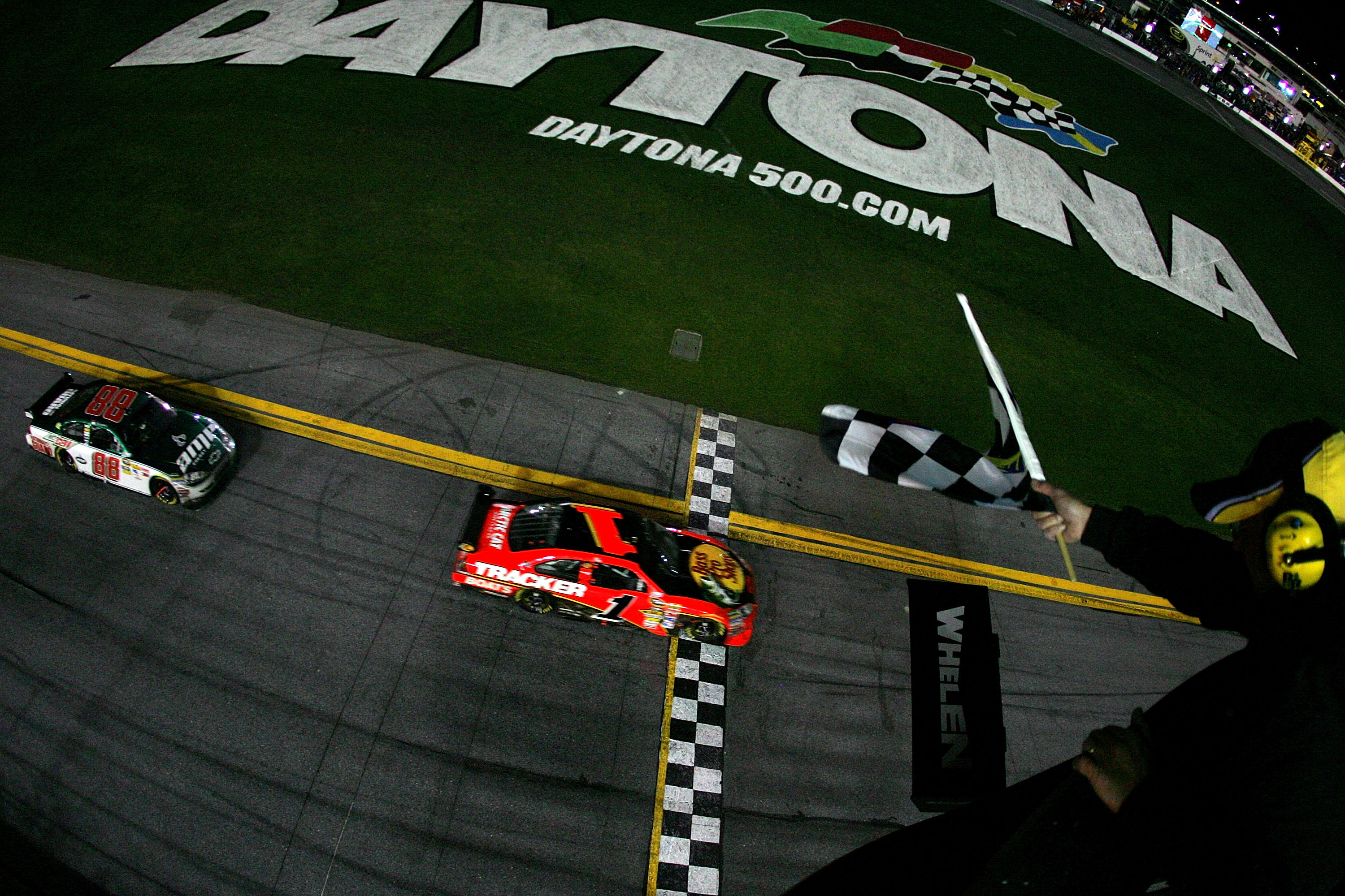 DAYTONA BEACH, FL - FEBRUARY 14:  Jamie McMurray, driver of the #1 Bass Pro Shops/Tracker Boats Chevrolet, crosses the finish line to win the the NASCAR Sprint Cup Series Daytona 500 followed by Dale Earnhardt Jr., driver of the #88 AMP Energy/National Gu