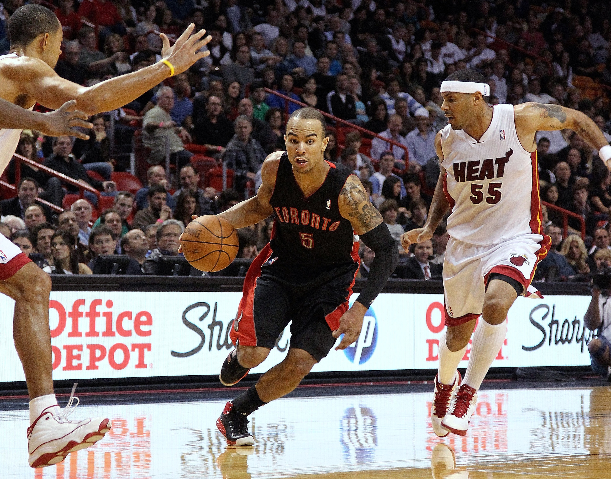 MIAMI, FL - JANUARY 22:  Jerryd Bayless #5 of the Toronto Raptors dribbles past Eddie House #55 of the Miami Heat during a game at American Airlines Arena on January 22, 2011 in Miami, Florida. NOTE TO USER: User expressly acknowledges and agrees that, by