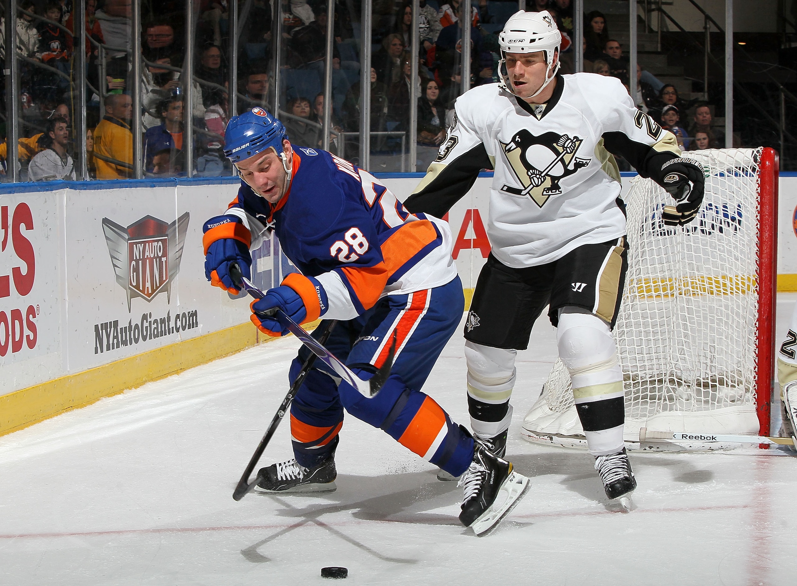 UNIONDALE, NY - FEBRUARY 11:  Zenon Konopka #28 of the New York Islanders steals the puck from Ryan Craig #23 of the Pittsburgh Penguins on February 11, 2011 at Nassau Coliseum in Uniondale, New York.  (Photo by Jim McIsaac/Getty Images)