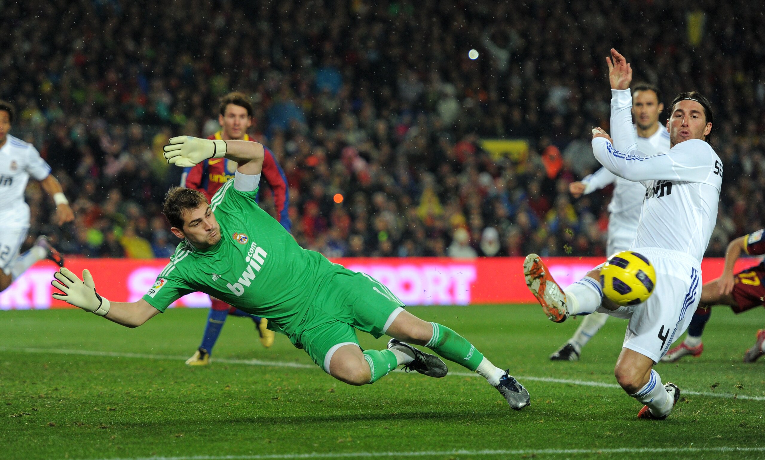 BARCELONA, SPAIN - NOVEMBER 29:  Goalkeeper Iker Casillas (L) of Real Madrid dives for a ball flanked by his teammate Sergio Ramos during the la liga match between Barcelona and Real Madrid at the Camp Nou stadium on November 29, 2010 in Barcelona, Spain.