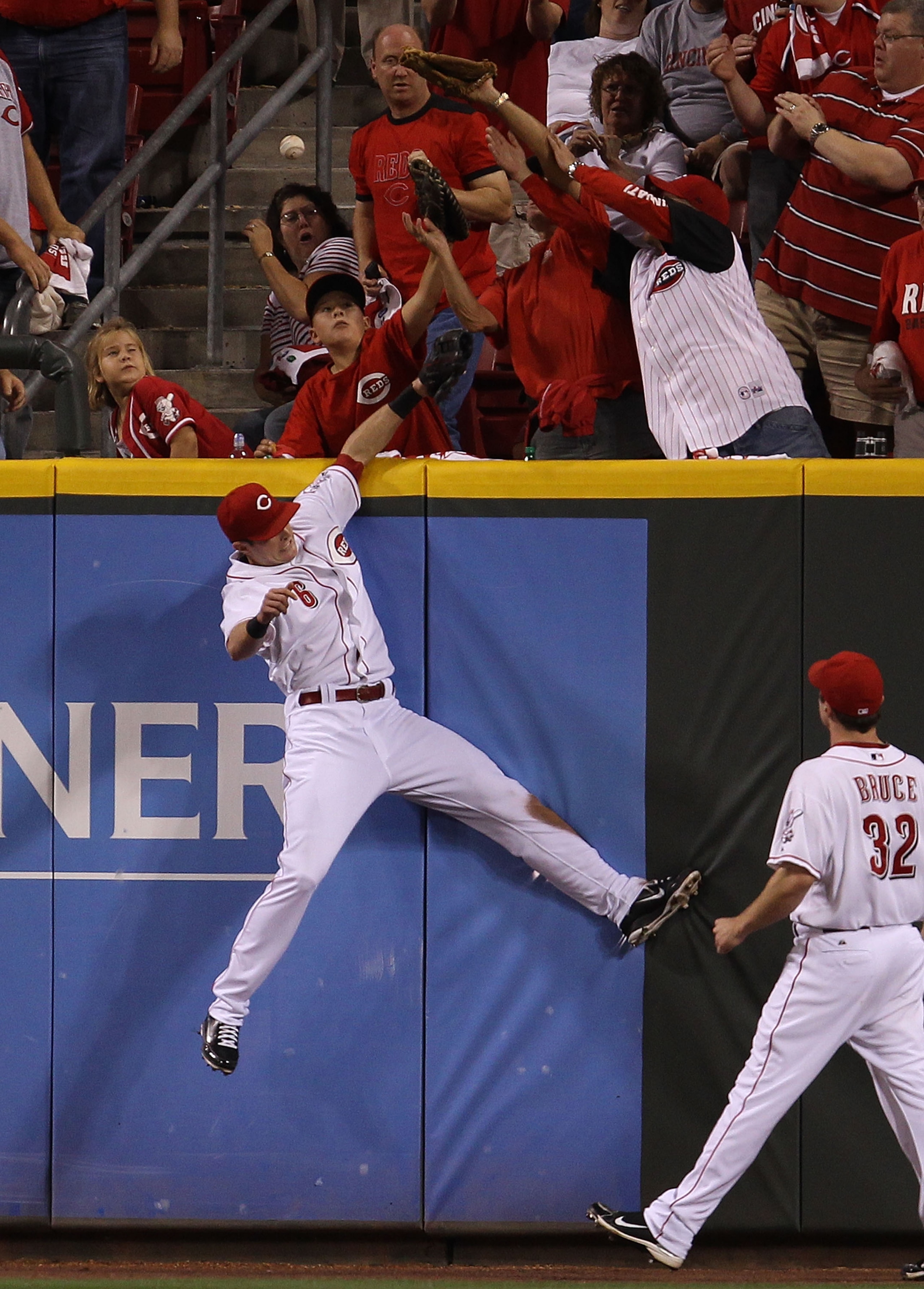 CINCINNATI - OCTOBER 10: Drew Stubbs #6 of the Cincinnati Reds leaps to try and catch a home run ball hit by Chase Utley of the Philadelphia Phillies during game 3 of the NLDS at Great American Ball Park on October 10, 2010 in Cincinnati, Ohio. (Photo by