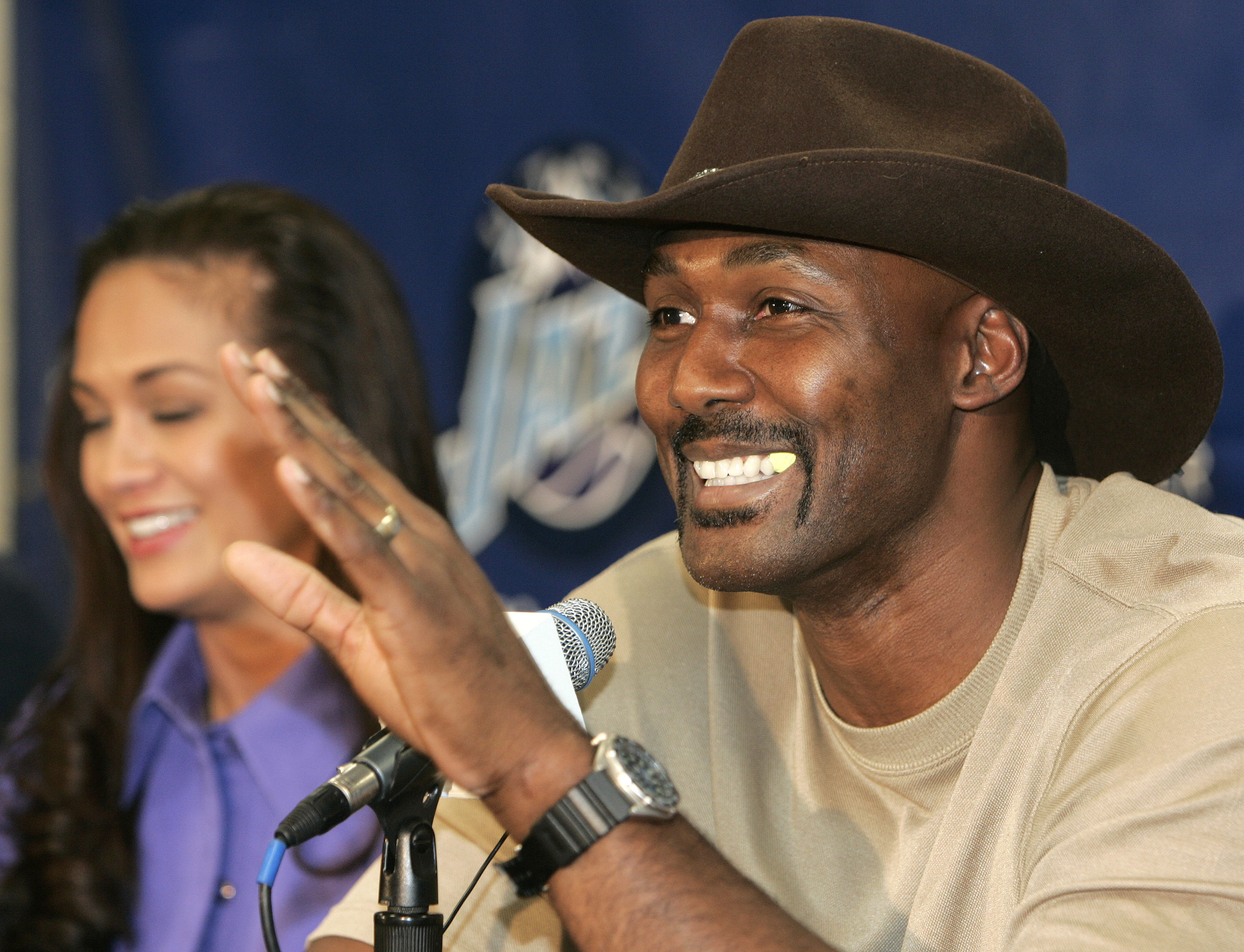 SALT LAKE CITY - FEBRUARY 13:  Karl Malone gestures as he announces his retirement from playing NBA basketball as his wife Kay (L) listens on February 13, 2005 at the Delta Center in Salt Lake City, Utah. Malone played 19 years in the NBA, 18 with the Uta