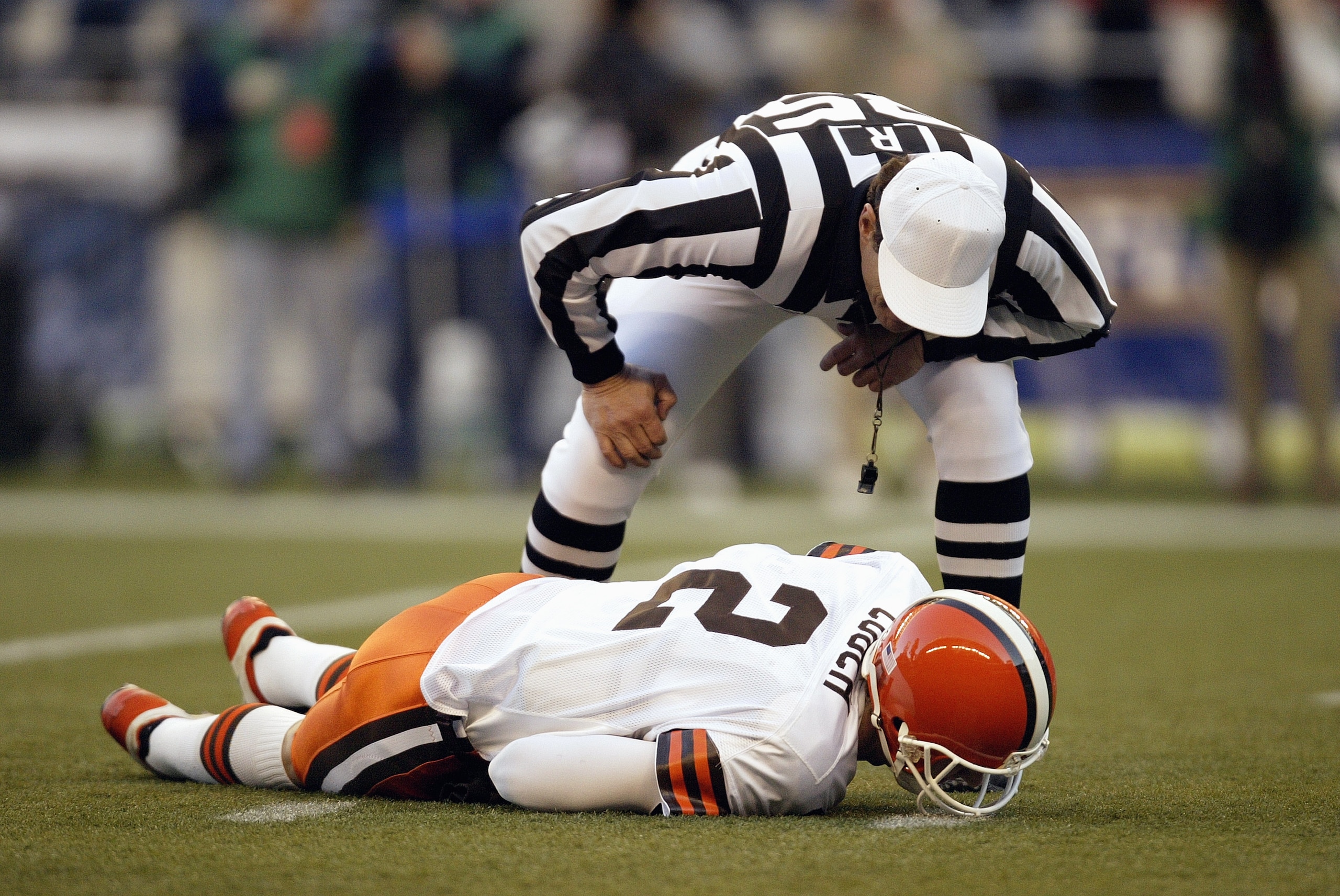 SEATTLE - NOVEMBER 30:  Referee Ed Hochuli #85 looks to help Quarterback Tim Couch #2 of the Cleveland Browns as he lays hurt during the game against the Seattle Seahawks on November 30 2003 at Seahawks Stadium in Seattle, Washington. The Seahawks defeate