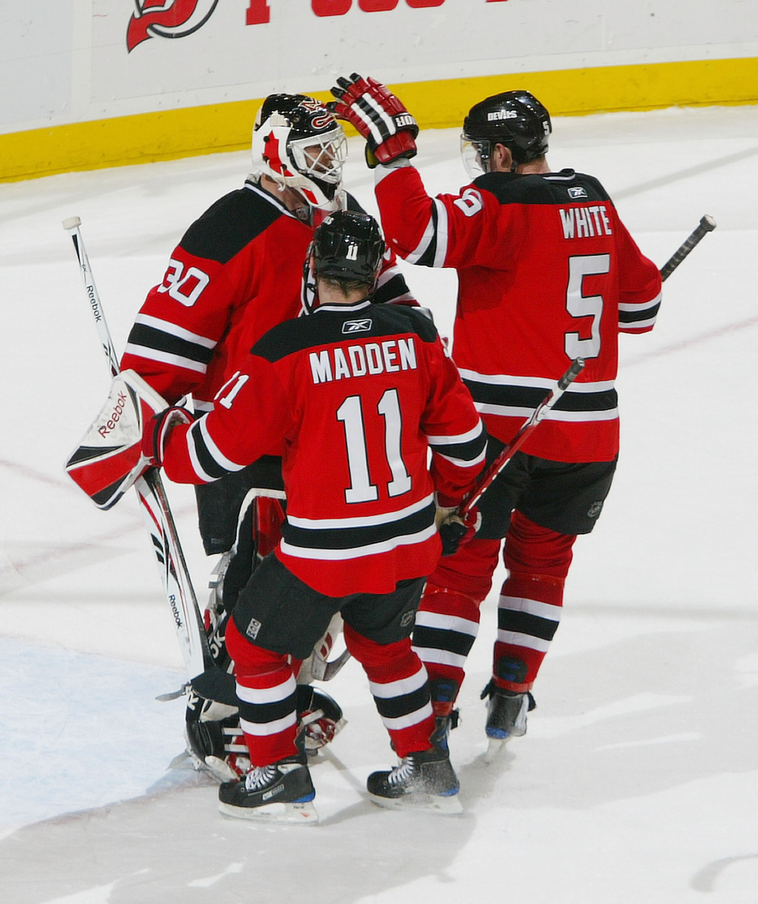 NEWARK, NJ - MARCH 01:  John Madden #11 and Colin White #5 congradulate teammate Martin Brodeur #30 of the New Jersey Devils after notching his 100th career regular season shutout against the Philadelphia Flyers at the Prudential Center on March 1, 2009 i