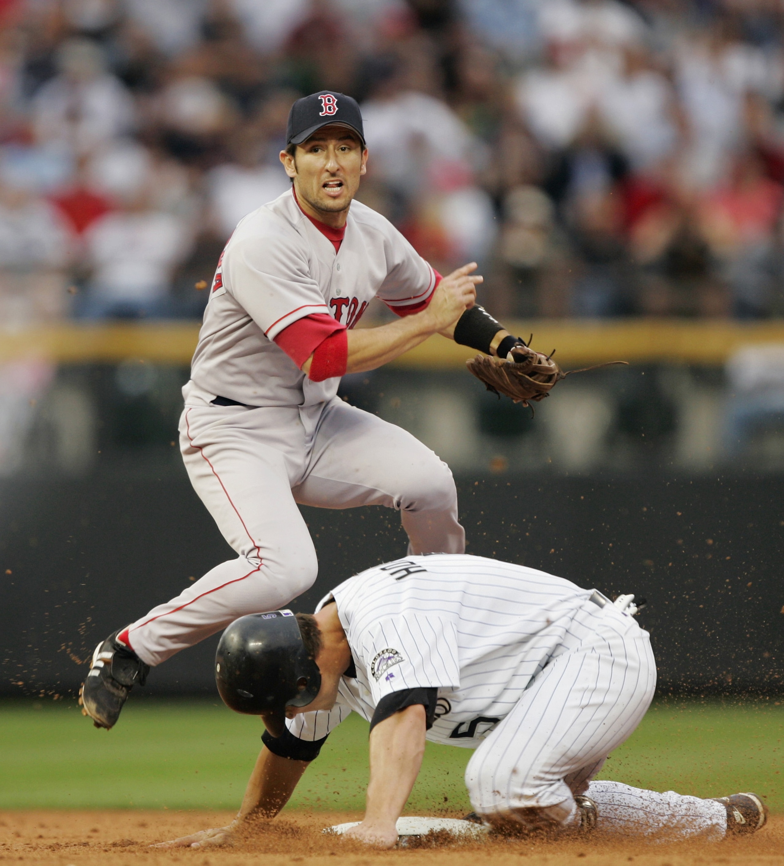 DENVER - JUNE 15: Shortstop Nomar Garciaparra #5 of the Boston Red Sox avoids Matt Holliday #5 of the Colorado Rockies after making the throw to late to complete a double play against Mark Sweeney in the second inning June 15, 2004 at Coors Field in Denv DENVER - JUNE 15: Shortstop Nomar Garciaparra #5 of the Boston Red Sox avoids Matt Holliday #5 of the Colorado Rockies after making the throw to late to complete a double play against Mark Sweeney in the second inning June 15, 2004 at Coors Field in Denv