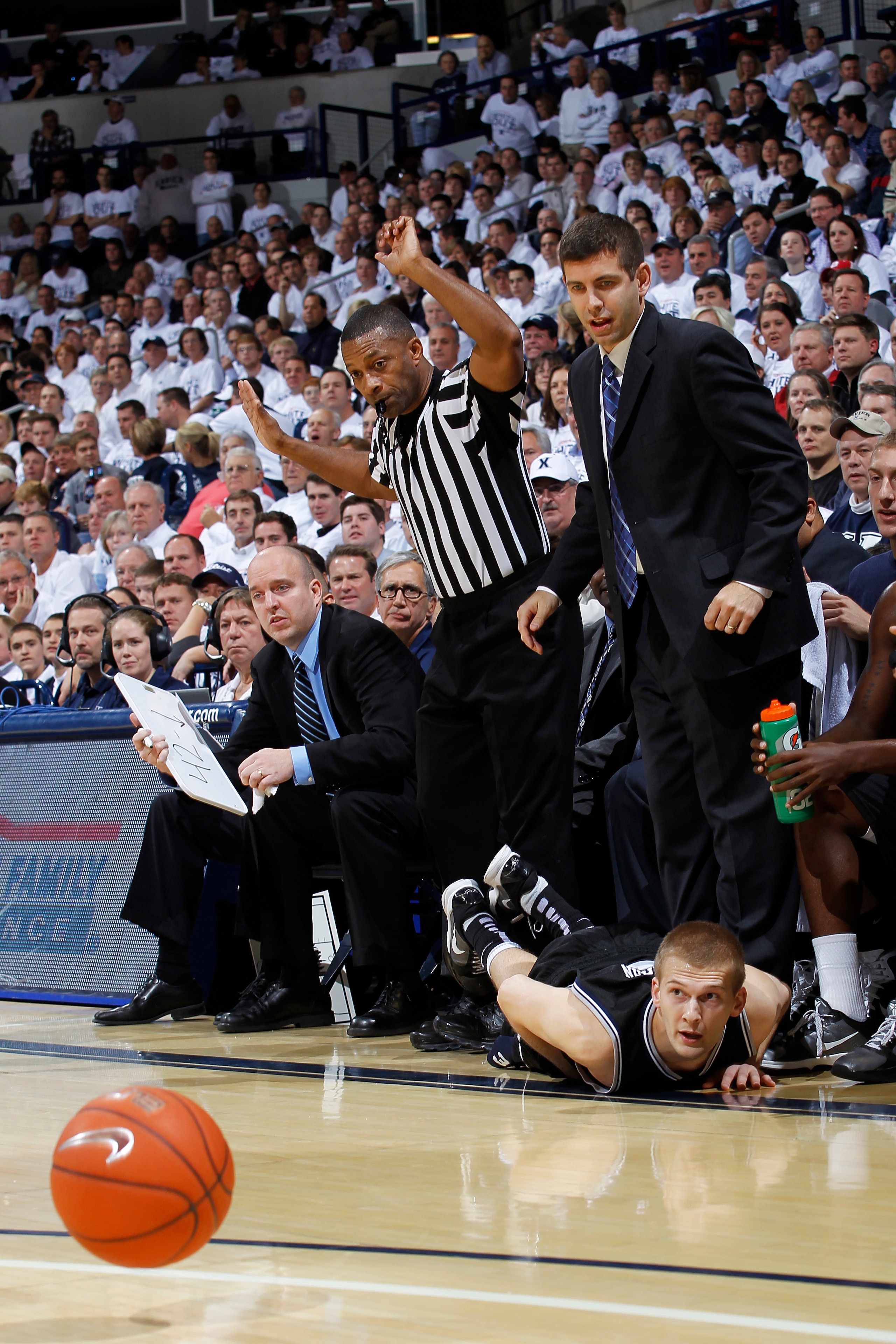 CINCINNATI, OH - DECEMBER 9: Zach Hahn #3 of the Butler Bulldogs falls out of bounds in front of head coach Brad Stevens while diving for a loose ball against the Xavier Musketeers at Cintas Center on December 9, 2010 in Cincinnati, Ohio. Xavier defeated