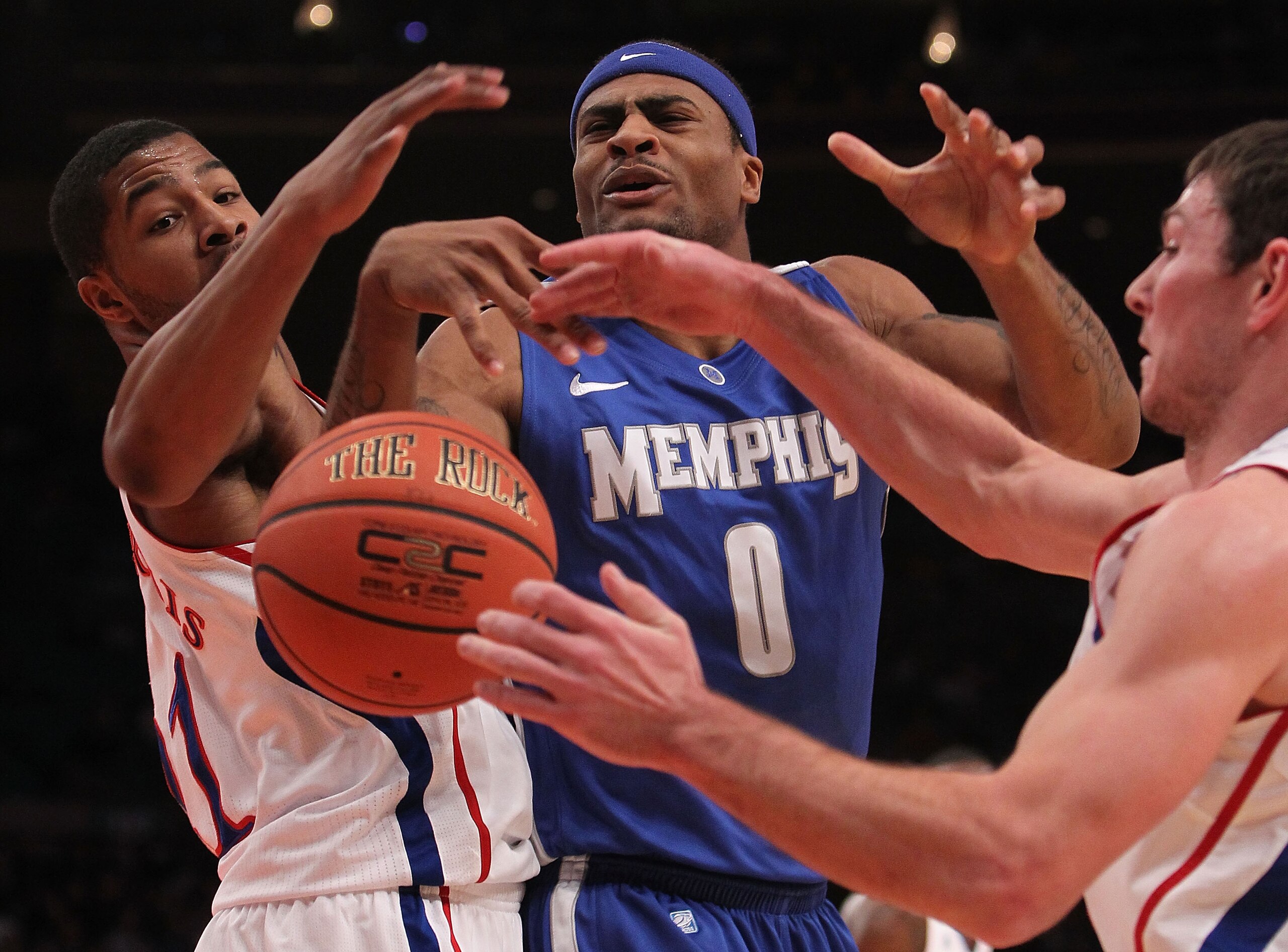 NEW YORK, NY - DECEMBER 07:  Will Coleman #0 of the Memphis Tigers has the ball stripped by Royce Woolridge #11 and Tyrel Reed #14 of the Kansas Jayhawks during their game at the Jimmy V Classic at Madison Square Garden on December 7, 2010 in New York Cit