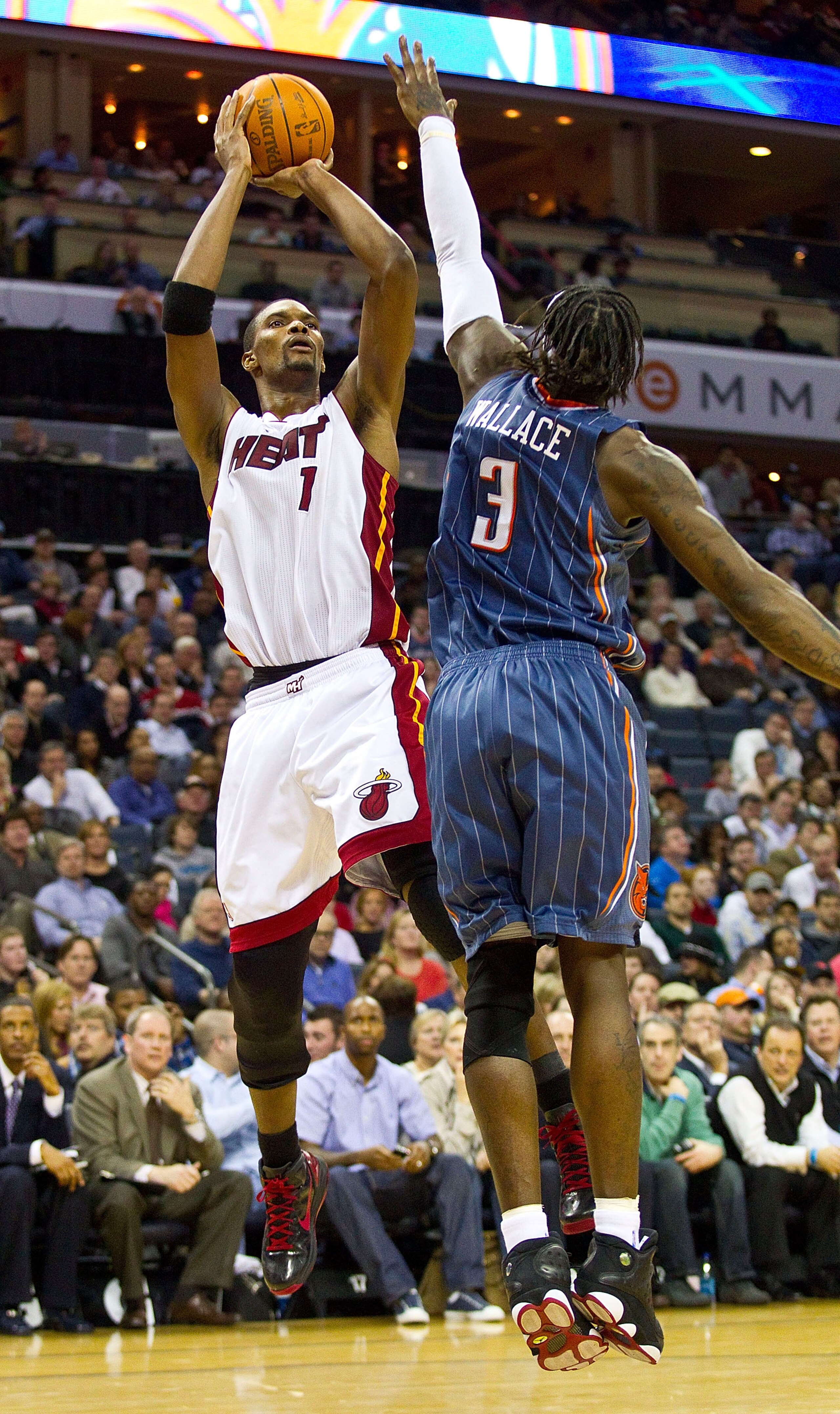 CHARLOTTE, NC - FEBRUARY 04:  Chris Bosh #1 of the Miami Heat takes a jump shot over Gerald Wallace #3 of the Charlotte Bobcats at the Time Warner Cable Arena on February 4, 2011 in Charlotte, North Carolina.  The Heat defeated the Bobcats 109-97.  NOTE T