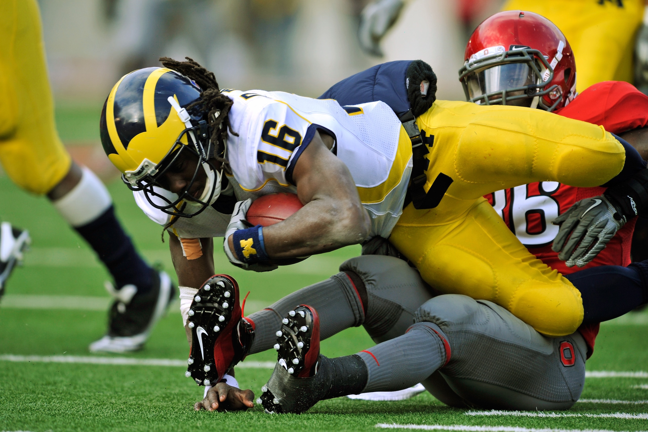 COLUMBUS, OH - NOVEMBER 27:  Quarterback Denard Robinson #16 of the Michigan Wolverines is sacked for a loss by Brian Rolle #36 of the Ohio State Buckeyes at Ohio Stadium on November 27, 2010 in Columbus, Ohio.  (Photo by Jamie Sabau/Getty Images)
