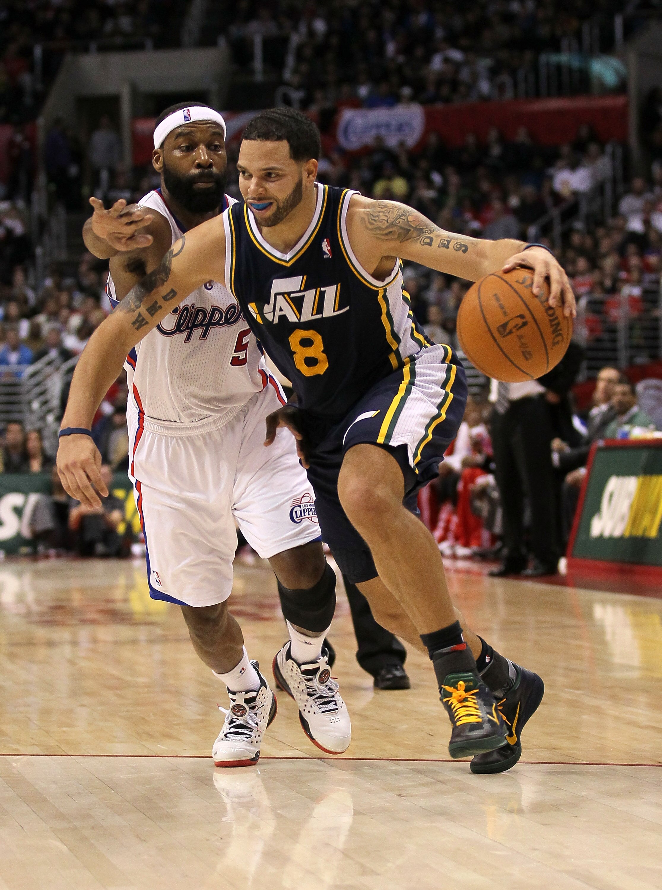 LOS ANGELES, CA - DECEMBER 29:  Deron Williams #8 of the Utah Jazz drives past Baron Davis #5 of the Los Angeles Clippers at Staples Center on December 29, 2010 in Los Angeles, California.   The Jazz won 103-85.  NOTE TO USER: User expressly acknowledges