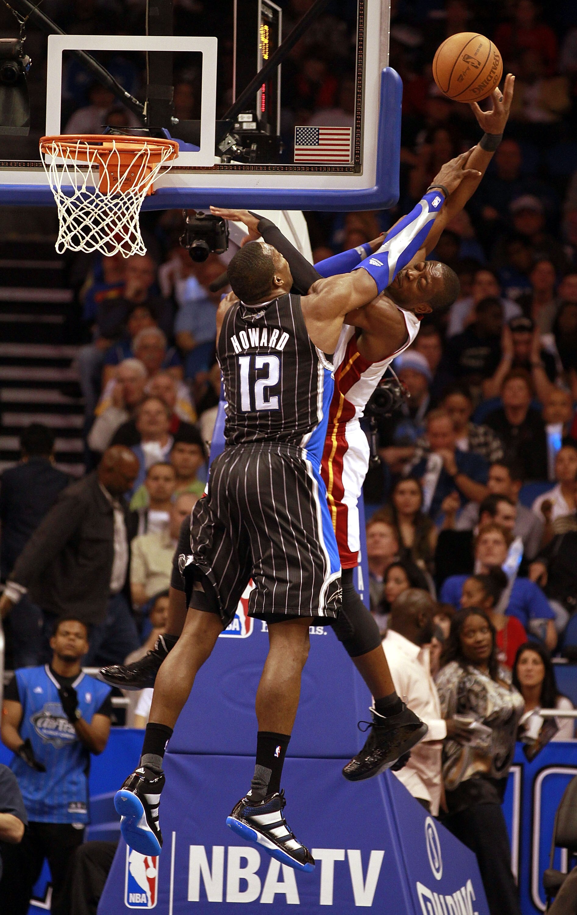 ORLANDO, FL - FEBRUARY 03:  Guard Dwyane Wade #3 of the Miami Heatis fouled by Center Dwight Howard #12 of the Orlando Magic at Amway Arena on February 3, 2011 in Orlando, Florida. NOTE TO USER: User expressly acknowledges and agrees that, by downloading 
