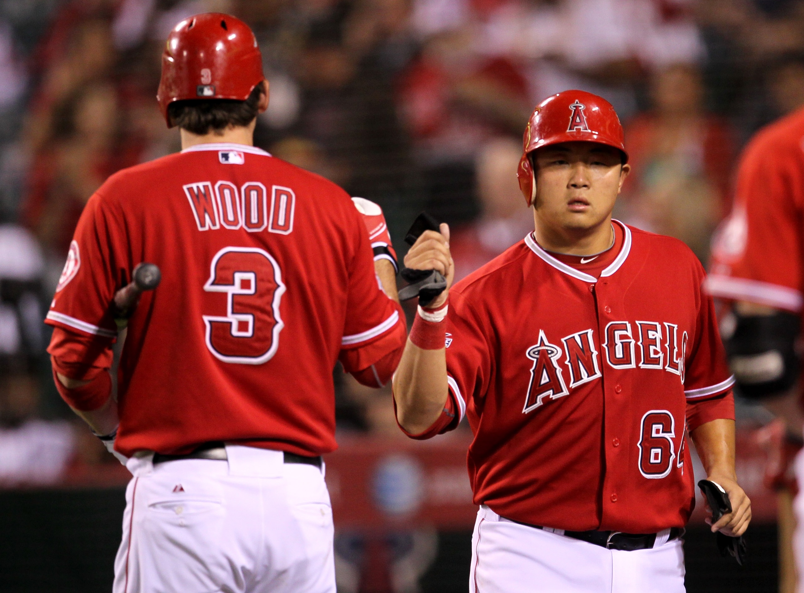 ANAHEIM, CA - SEPTEMBER 21:  Hank Conger #64 of the Los Angeles Angels of Anaheim is greeted by Brandon Wood #3 as he returns to the dugout after scoring a run in the second inning against the Texas Rangers on September 21, 2010 at Angel Stadium in Anahei