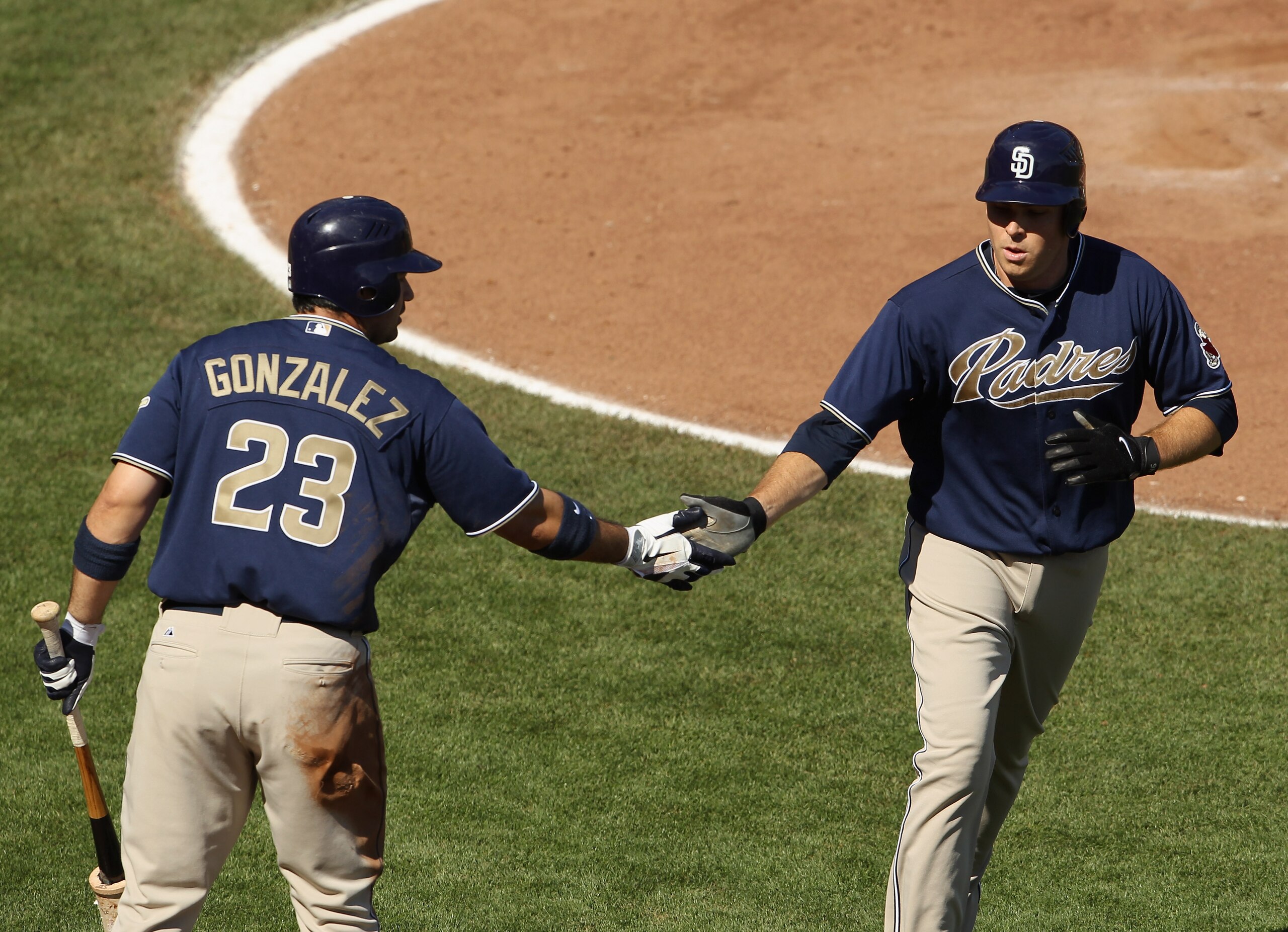 SAN FRANCISCO - OCTOBER 02:  Tim Stauffer #46 of the San Diego Padres is congratulated by Adrian Gonzalez #23 after Stauffer scored on a single by Miguel Tejada to give the Padres a 4-0 lead in the fourth inning over the San Francisco Giants at AT&T Park