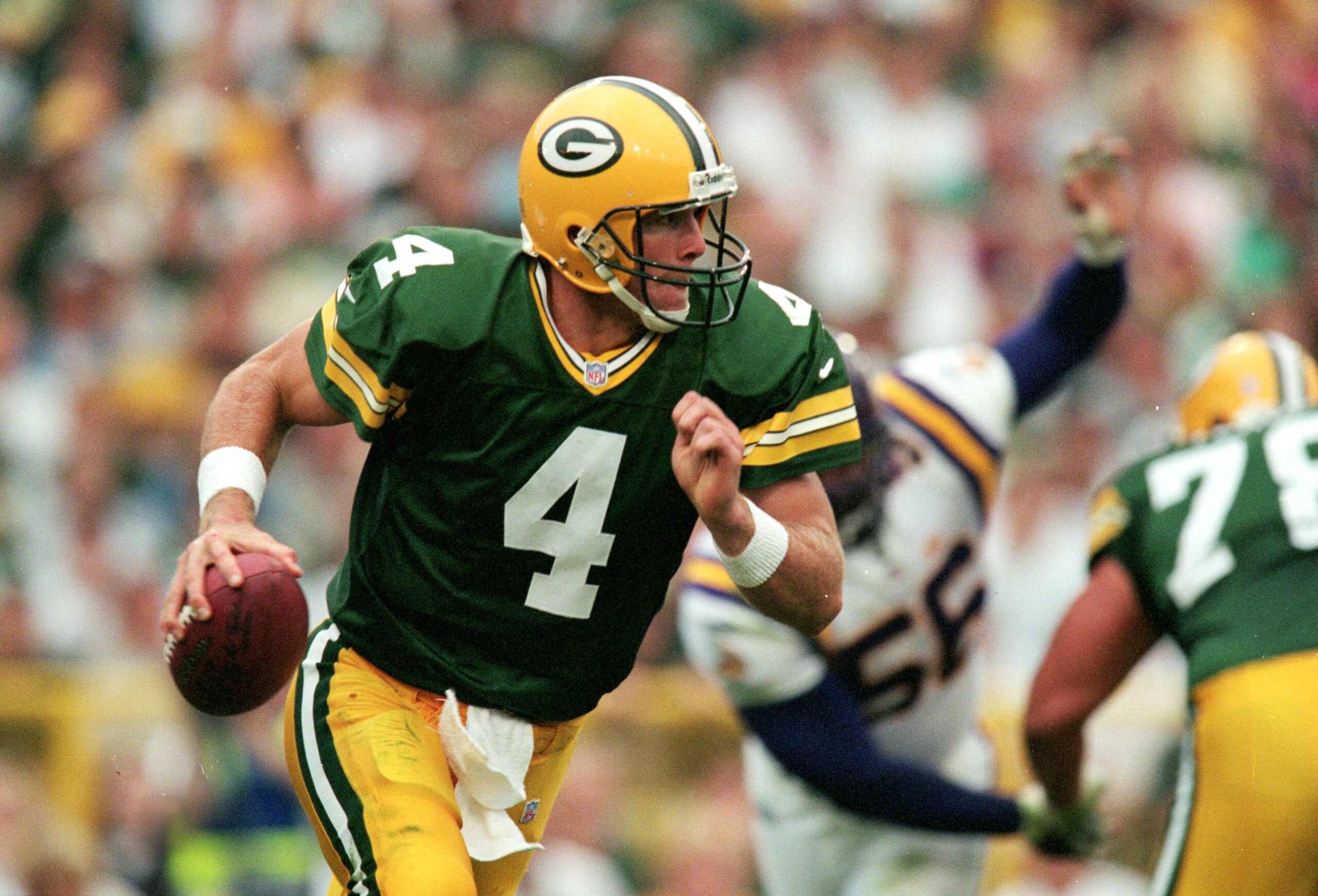 26 Sep 1999: Brett Favre #4 of the Green Bay Packers carries the ball during the game against the Minnesota Vikings at Lambeau Field in Green Bay, Wisconsin. The Packers defeated the Vikings 23-20.  (Photo by Brian Bahr/Getty Images)