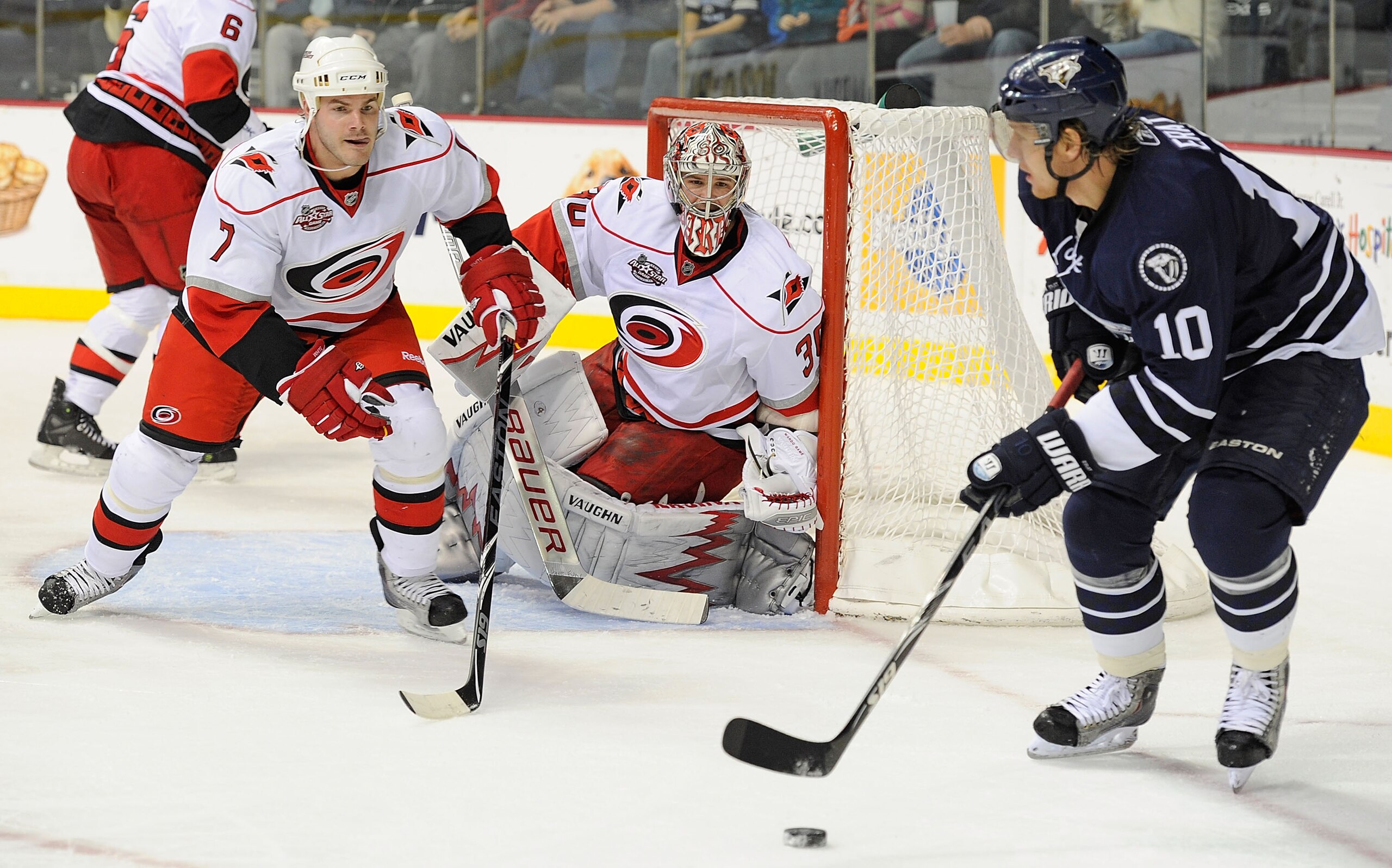 NASHVILLE, TN - DECEMBER 04:  Martin Erat #10 of the Nashville Predators skates against Ian White #7 and Cam Ward #30 of the Carolina Hurricanes on December 4, 2010 at the Bridgestone Arena in Nashville, Tennessee.  (Photo by Frederick Breedon/Getty Image