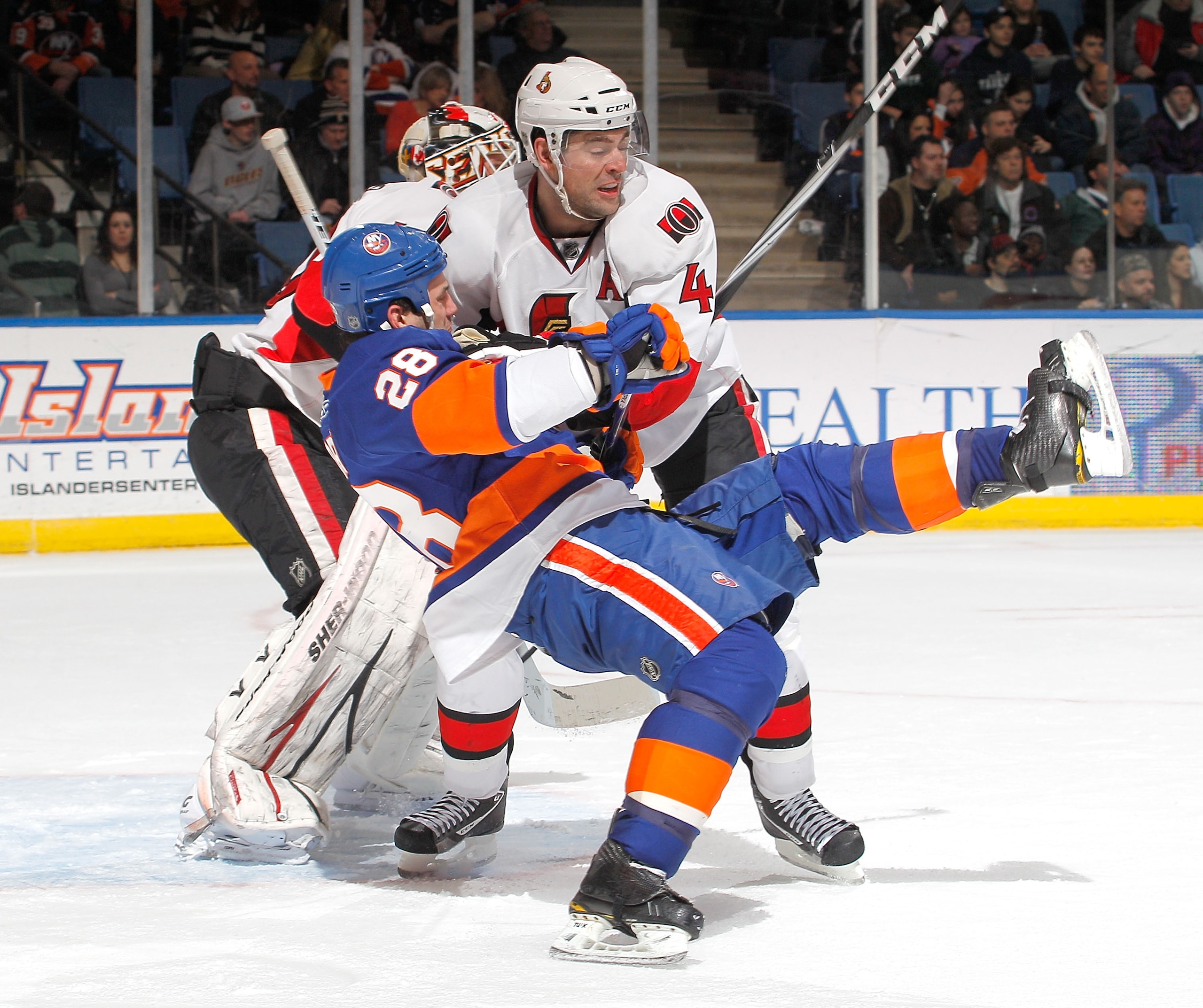 UNIONDALE, NY - FEBRUARY 05:  Chris Phillips #4 of the Ottawa Senators gets a penalty here as he takes down Zenon Konopka #28 of the New York Islanders during the second period of an NHL hockey game at the Nassau Coliseum on February 5, 2011 in Uniondale,