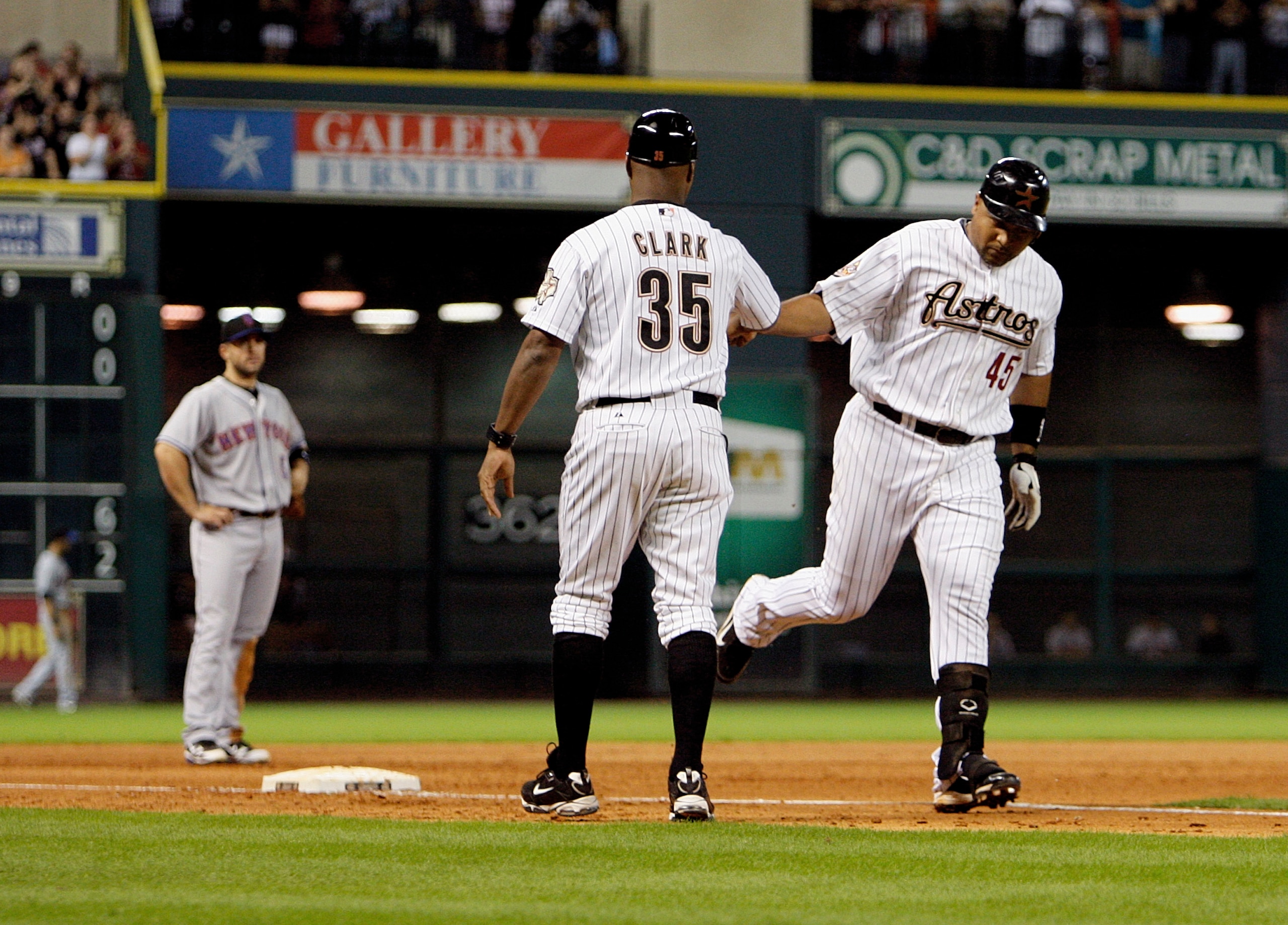 HOUSTON - AUGUST 19:  Carlos Lee #45 of the Houston Astros is congratulated by third base coach Dave Clark #35 after hitting a three run home run in the seventh inning against the New York Mets at Minute Maid Park on August 19, 2010 in Houston, Texas.  (P