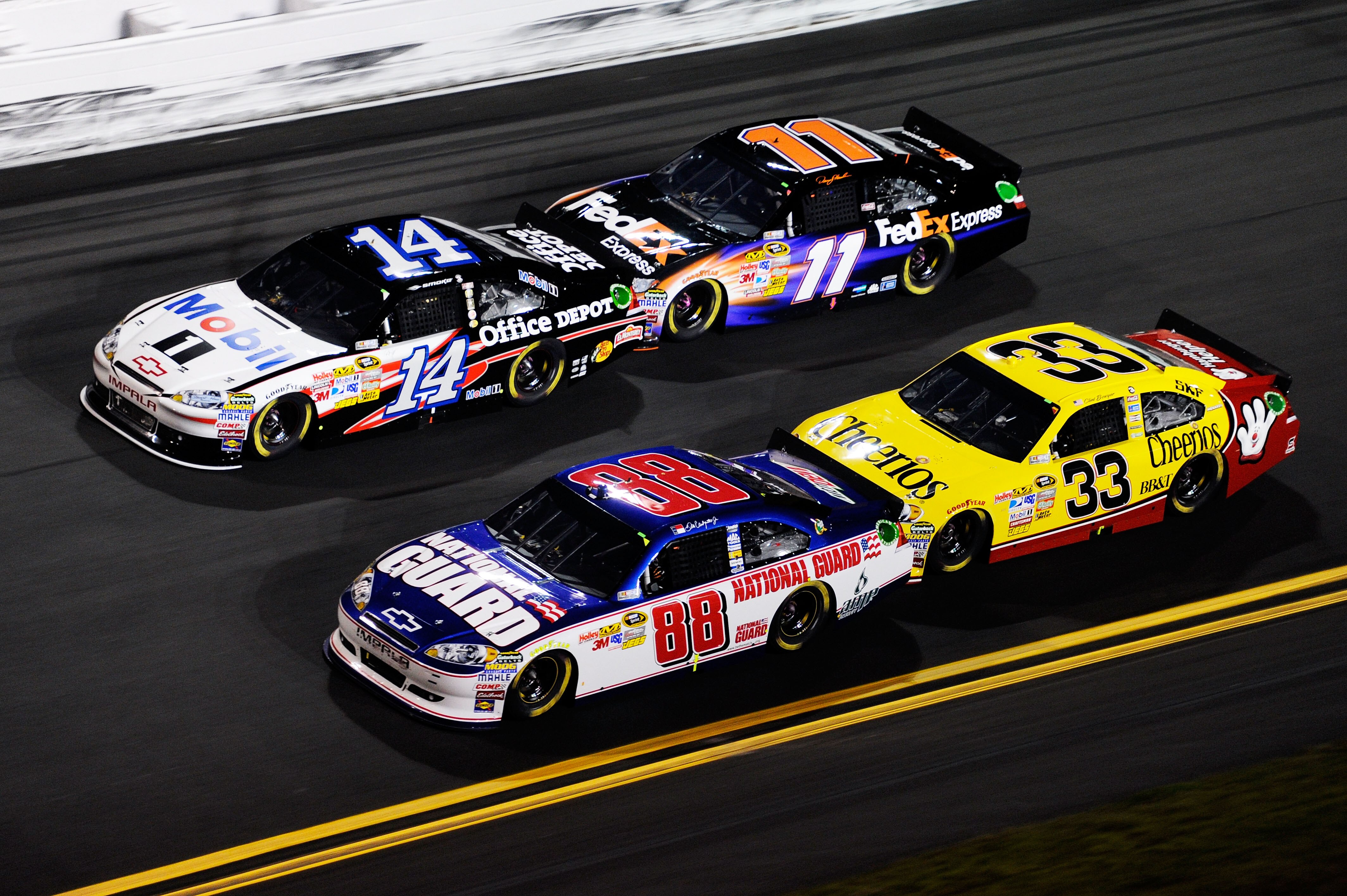 DAYTONA BEACH, FL - FEBRUARY 12:  Dale Earnhardt Jr., driver of the #88 National Guard/AMP Energy Chevrolet, races Tony Stewart, driver of the #14 Mobil 1/Office Depot Chevrolet, Clint Bowyer, driver of the #33 Cheerios Chevrolet, and Denny Hamlin, driver