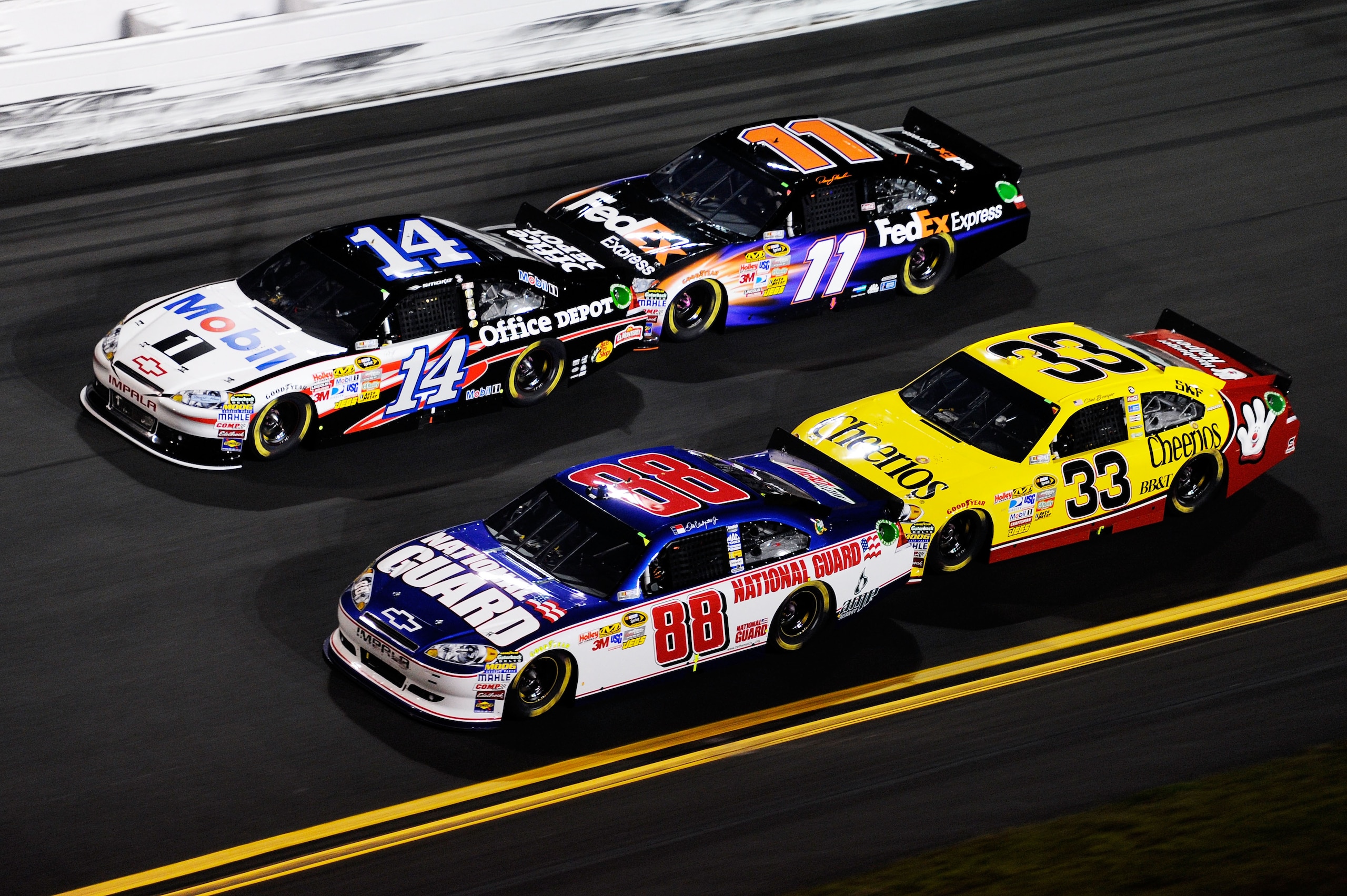 DAYTONA BEACH, FL - FEBRUARY 12:  Dale Earnhardt Jr., driver of the #88 National Guard/AMP Energy Chevrolet, races Tony Stewart, driver of the #14 Mobil 1/Office Depot Chevrolet, Clint Bowyer, driver of the #33 Cheerios Chevrolet, and Denny Hamlin, driver