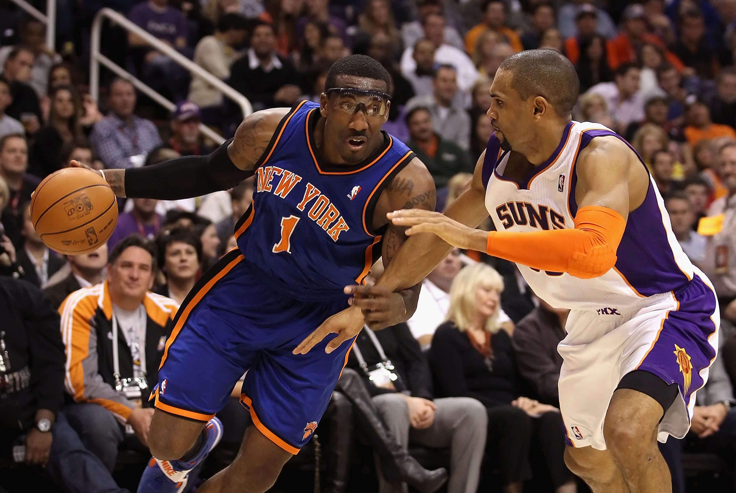 PHOENIX - JANUARY 07:  Amar'e Stoudemire #1 of the New York Knicks drives the ball against Grant Hill #33 of the Phoenix Suns during the NBA game at US Airways Center on January 7, 2011 in Phoenix, Arizona.  NOTE TO USER: User expressly acknowledges and a