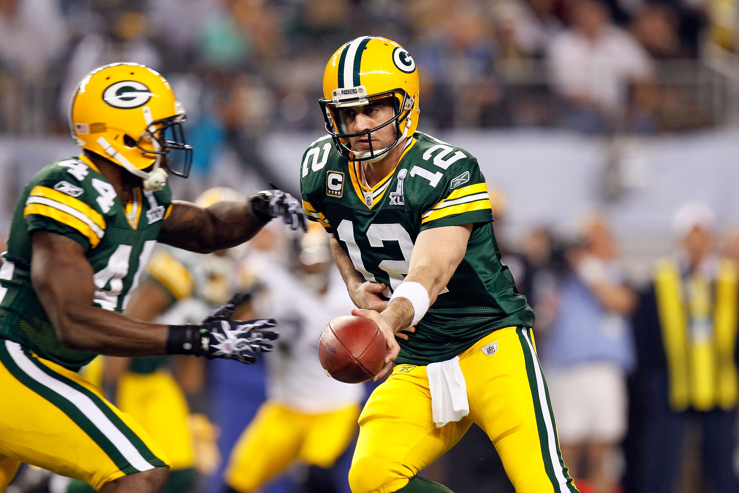 ARLINGTON, TX - FEBRUARY 06:  Aaron Rodgers #12 of the Green Bay Packers turns to nad the ball off to James Starks #44 of agains the Pittsburgh Steelers during Super Bowl XLV at Cowboys Stadium on February 6, 2011 in Arlington, Texas. The Packers won 31-2