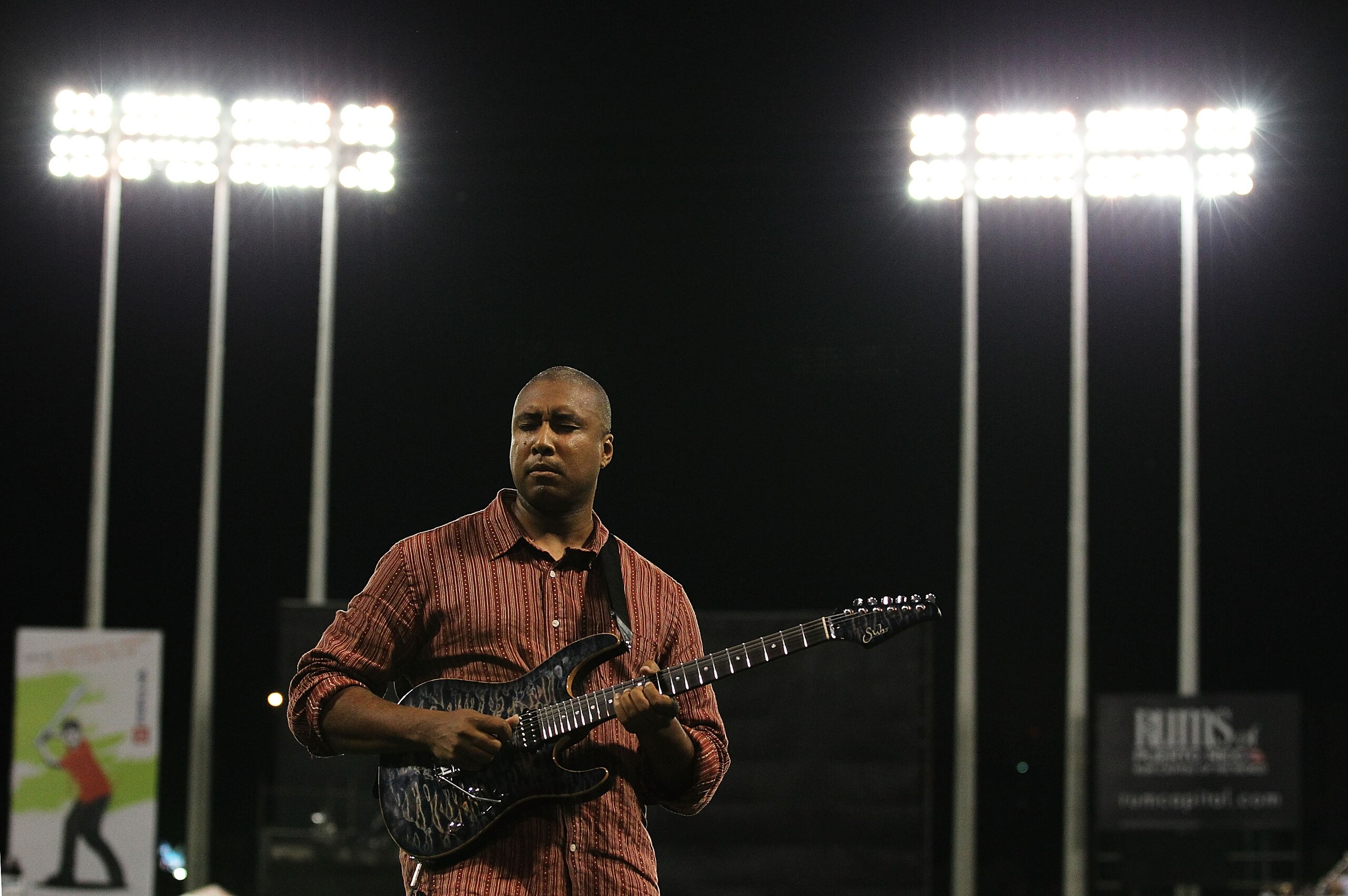 SAN JUAN, PUERTO RICO - JUNE 30:  Musician and former baseball player of the New York Yankees Bernie Williams plays the national anthem on his guitar before the game between the New York Mets and the Florida Marlins at Hiram Bithorn Stadium on June 30, 20