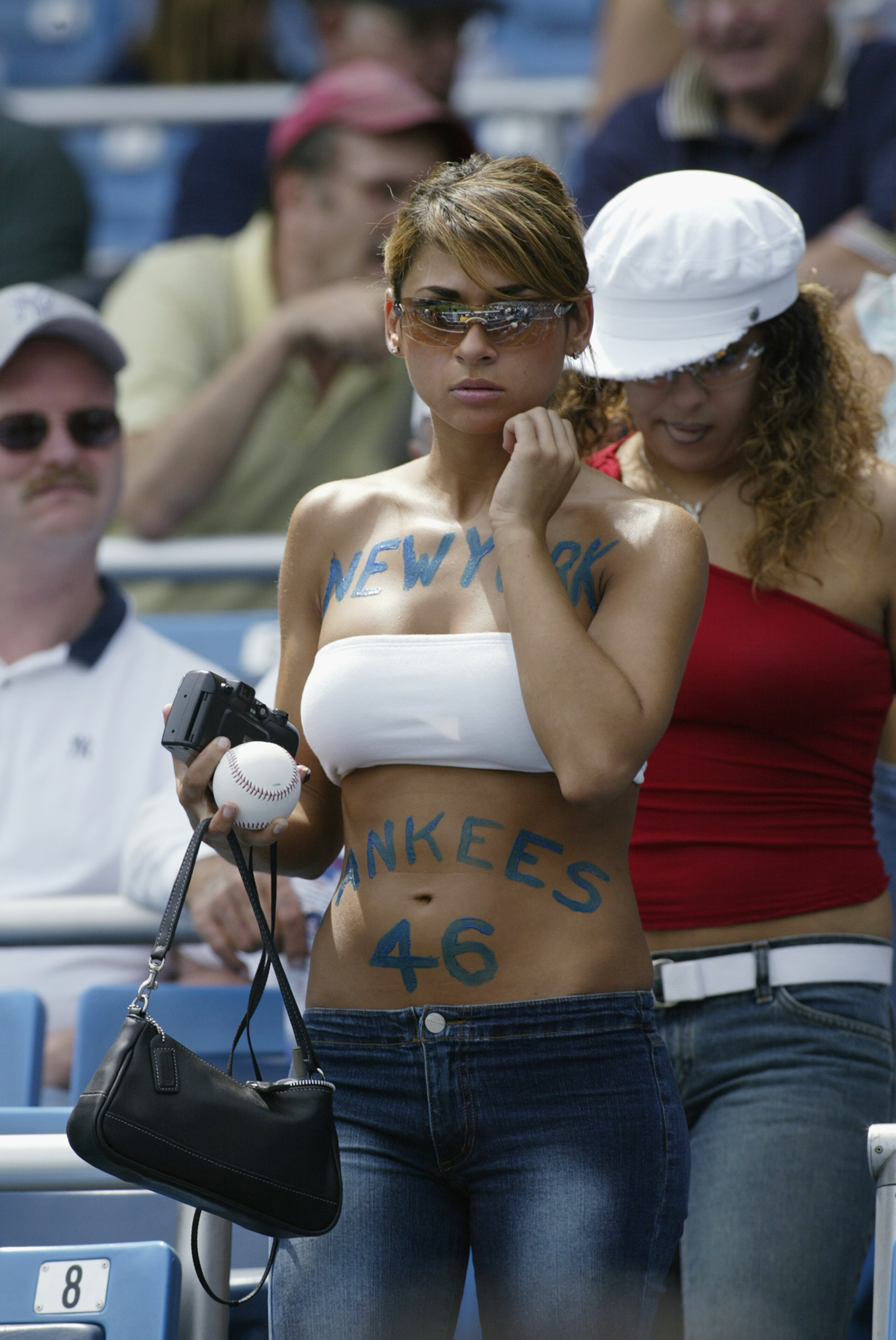 BRONX, NY - AUGUST 26:  Woman fan of the New York Yankees heading to her seat during the game against the Texas Rangers at Yankee Stadium in the Bronx, New York, on August 26, 2002. The Yankees defeated the Rangers 10-3. (Photo by Ronald Martinez/Getty Im