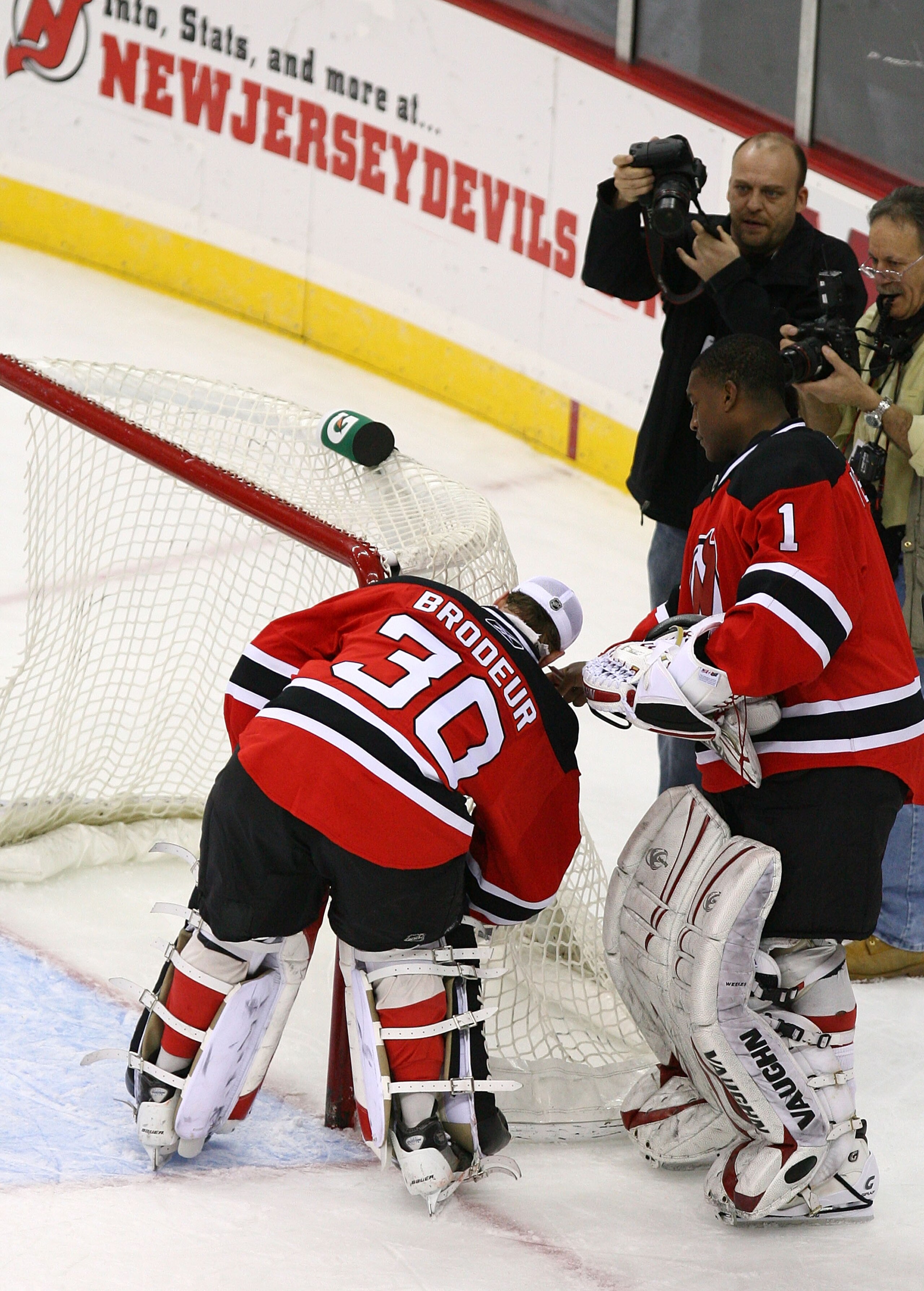 NEWARK, NJ - MARCH 17:  Goaltender Martin Brodeur #30 of the New Jersey Devils  cuts down the net as Kevin Weekes #1 stands by  in honor of becoming the winningest goaltender in history with 552 wins after defeating the Chicago Blackhawks 3-2 at the Prude