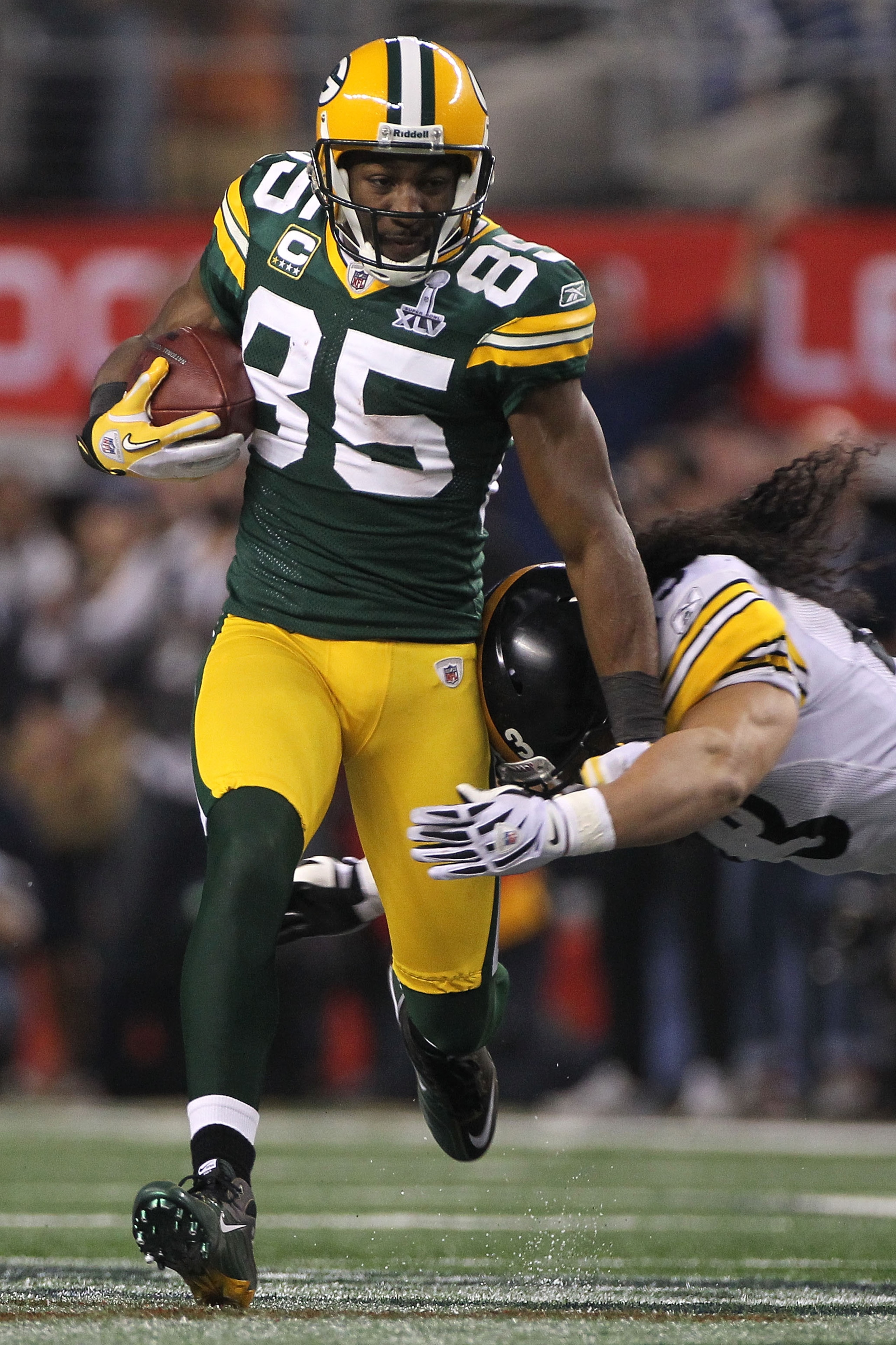 ARLINGTON, TX - FEBRUARY 06:  Greg Jennings #85 of the Green Bay Packers runs after a catch before getting hit by Troy Polamalu #43 of the Pittsburgh Steelers during Super Bowl XLV at Cowboys Stadium on February 6, 2011 in Arlington, Texas.  (Photo by Dou