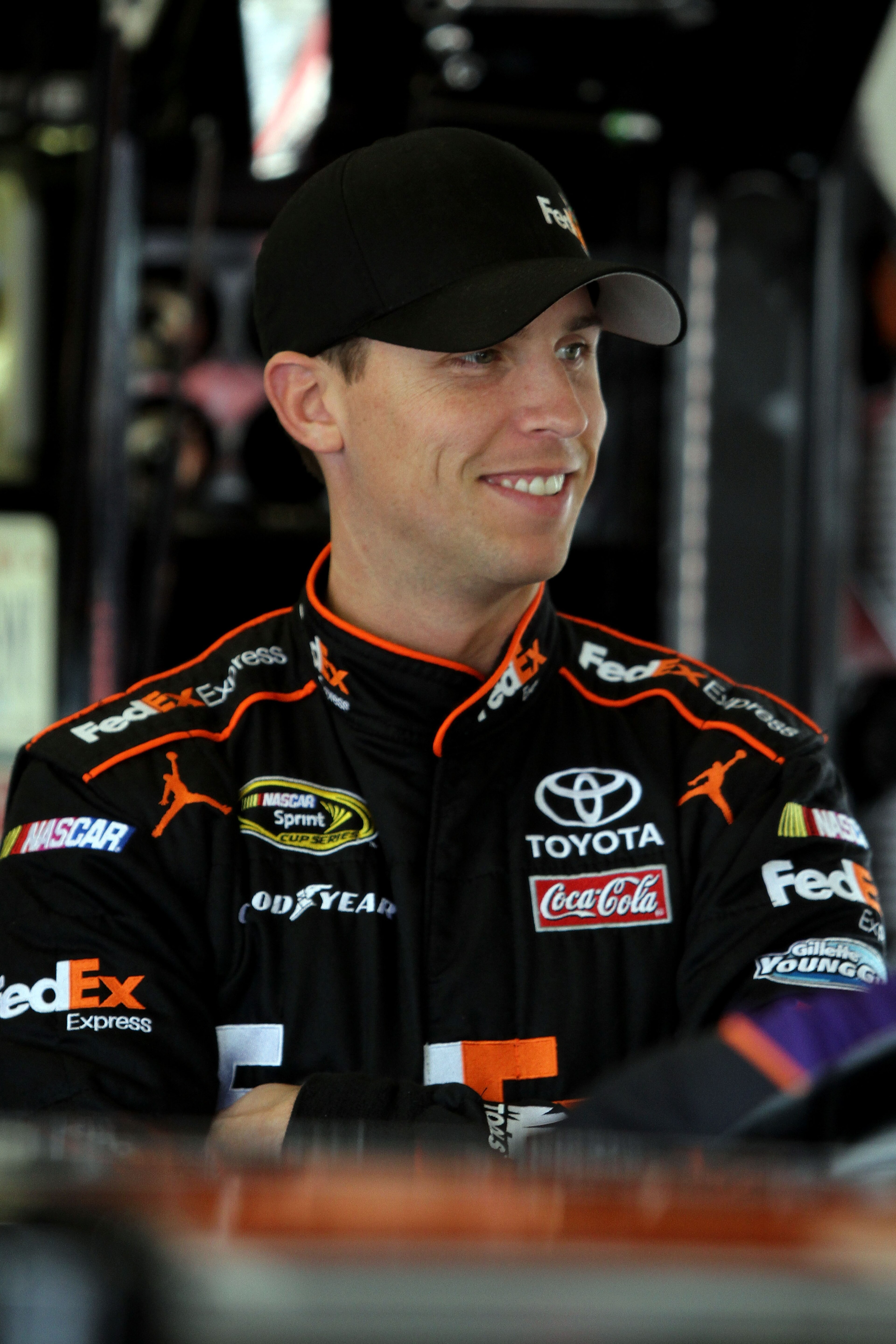 DAYTONA BEACH, FL - FEBRUARY 16:  Denny Hamlin, driver of the #11 FedEx Toyota, looks on in the garage area during practice for the NASCAR Sprint Cup Series Daytona 500 at Daytona International Speedway on February 16, 2011 in Daytona Beach, Florida.  (Ph