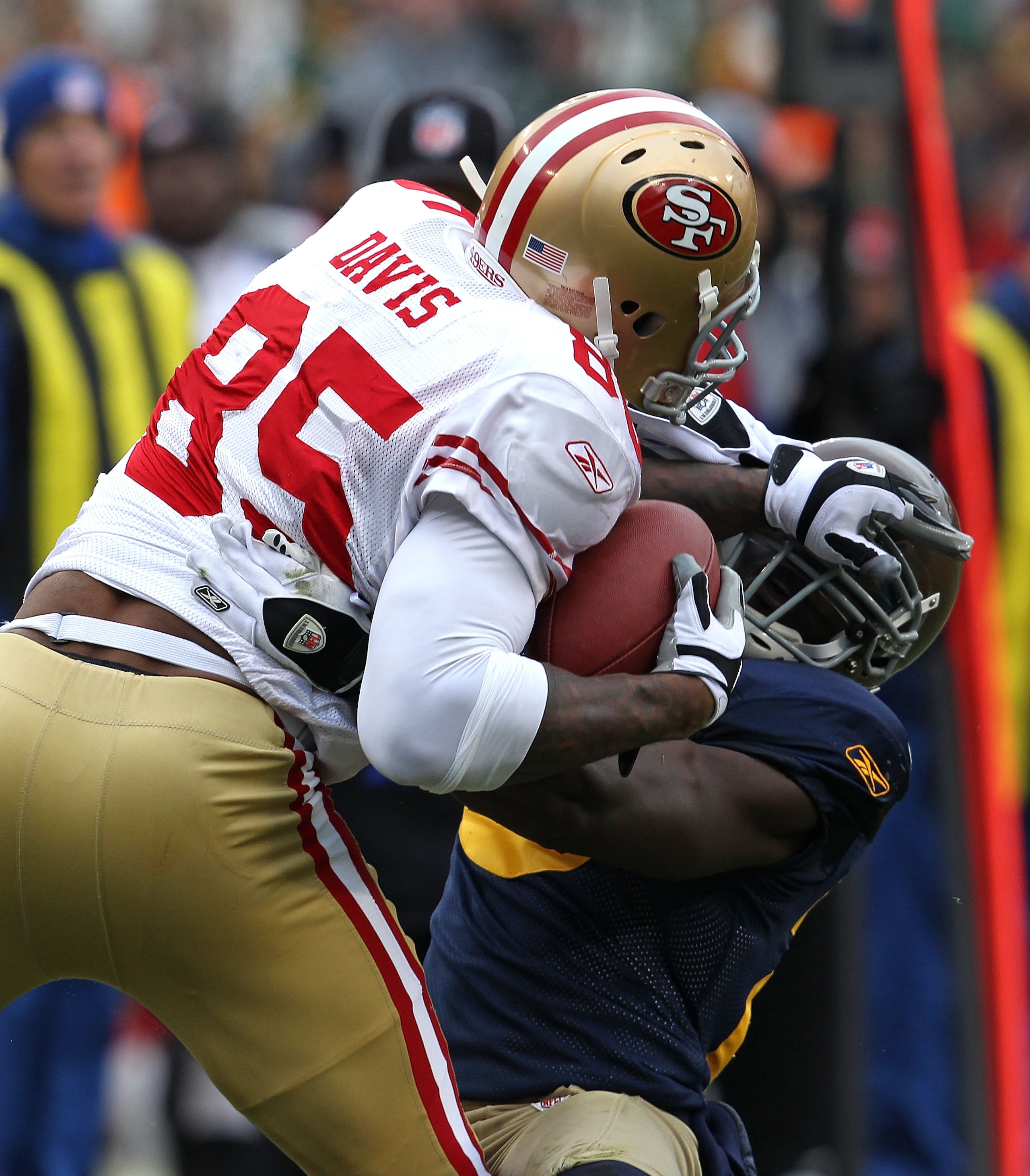 GREEN BAY, WI - DECEMBER 05: Vernon Davis #85 of the San Francisco 49ers catches a pass over Charlie Peprah #26 of the Green Bay Packers at Lambeau Field on December 5, 2010 in Green Bay, Wisconsin. The Packers defeated the 49ers 34-16. (Photo by Jonathan