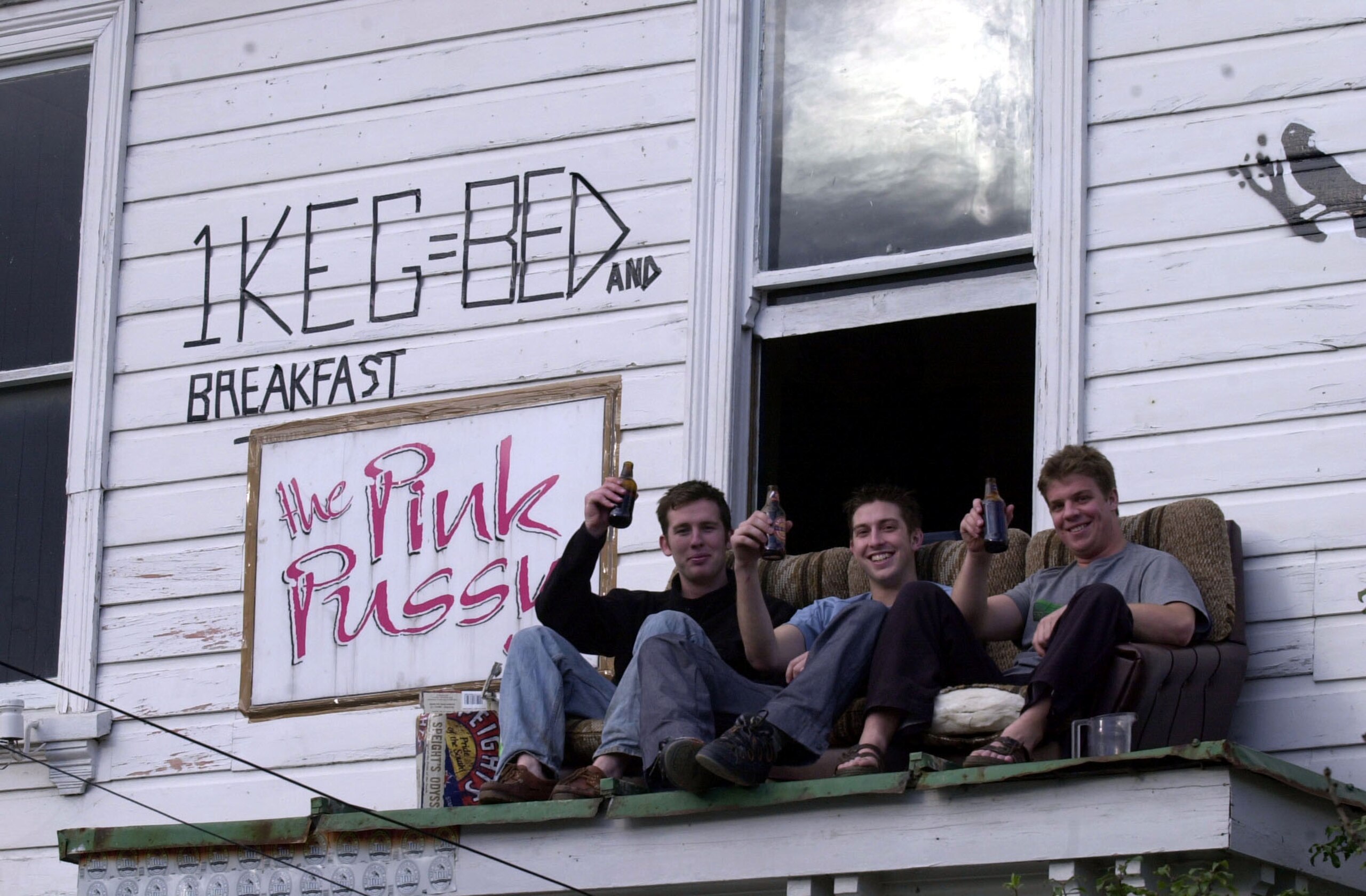 NEW ZEALAND - AUGUST 10:  Enterprising students (L to R) Brett Henderson, Mark Priscott and Patrick Kershaw, all from Masterton, wait for takers after placing their sign (1 Keg = Bed and Breakfast) on the upstairs wall of their Dunedin flat. The town has