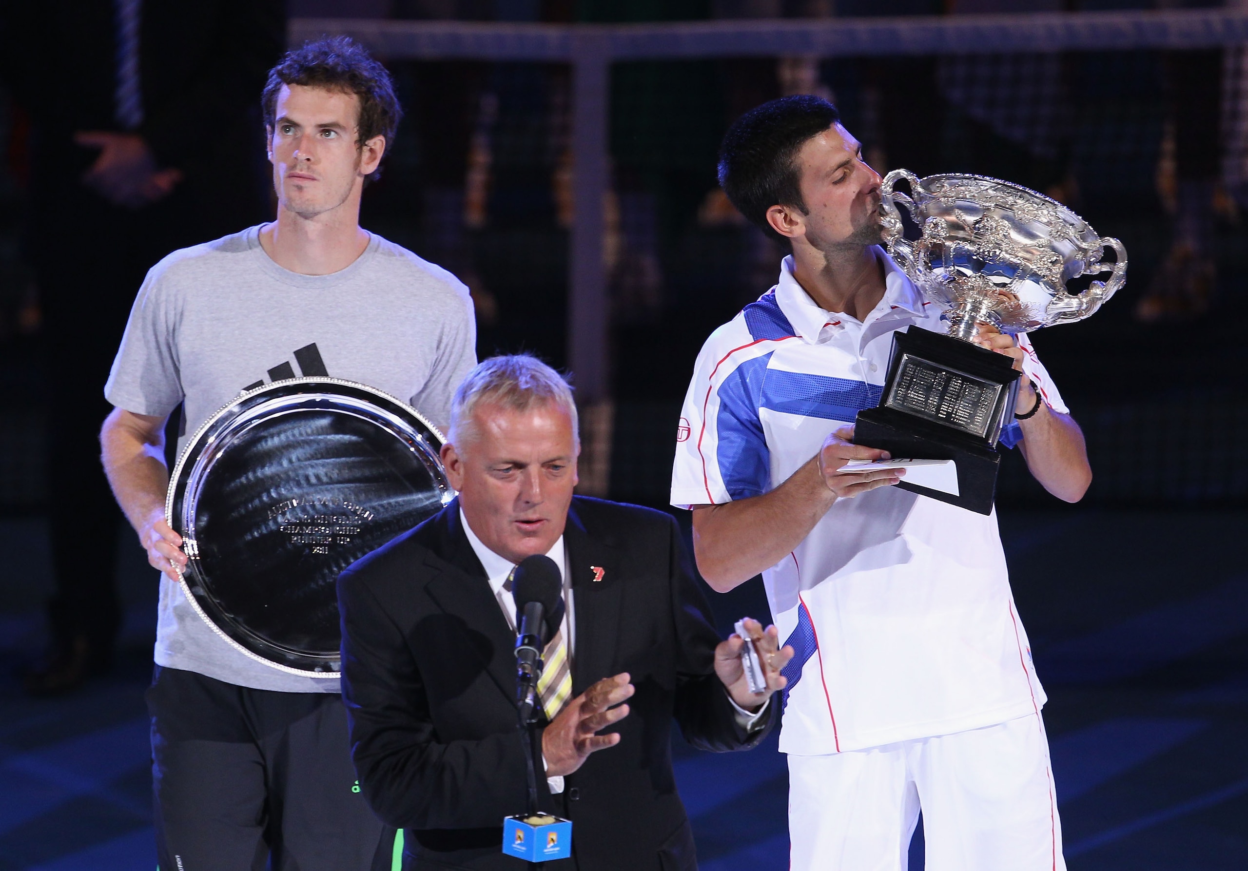 MELBOURNE, AUSTRALIA - JANUARY 30: Sandy Roberts (C) congratulates Novak Djokovic of Serbia (R) on winning the Norman Brookes Challenge Cup after winning his men's final match against Andy Murray of Great Britain (L) during day fourteen of the 2011 Austra