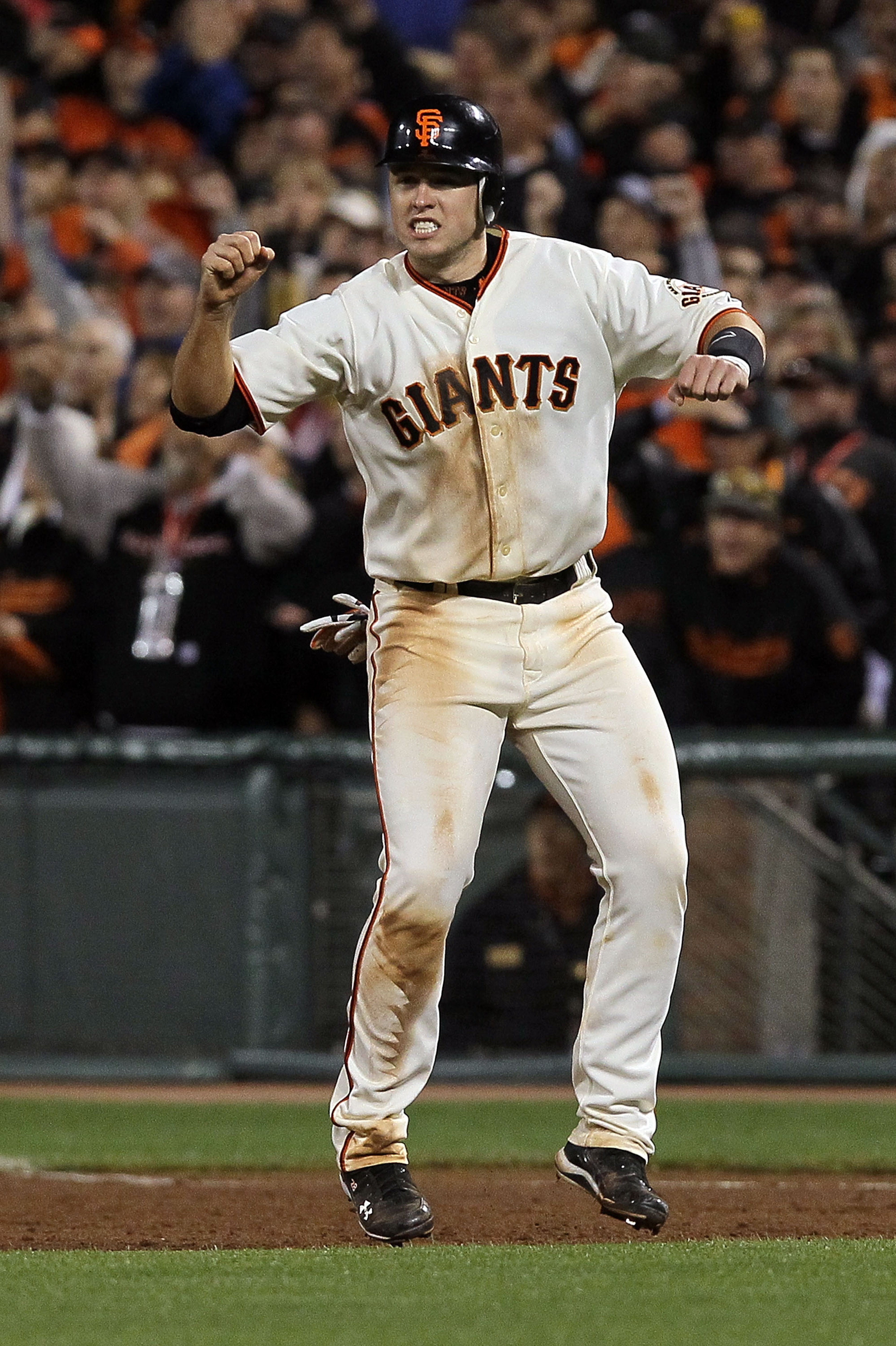 SAN FRANCISCO - OCTOBER 20:  Buster Posey #28 of the San Francisco Giants reacts to Juan Uribe #5 hitting a sacrifice fly, scoring Aubrey Huff #17 to win 6-5 over the Philadelphia Phillies in Game Four of the NLCS during the 2010 MLB Playoffs at AT&T Park