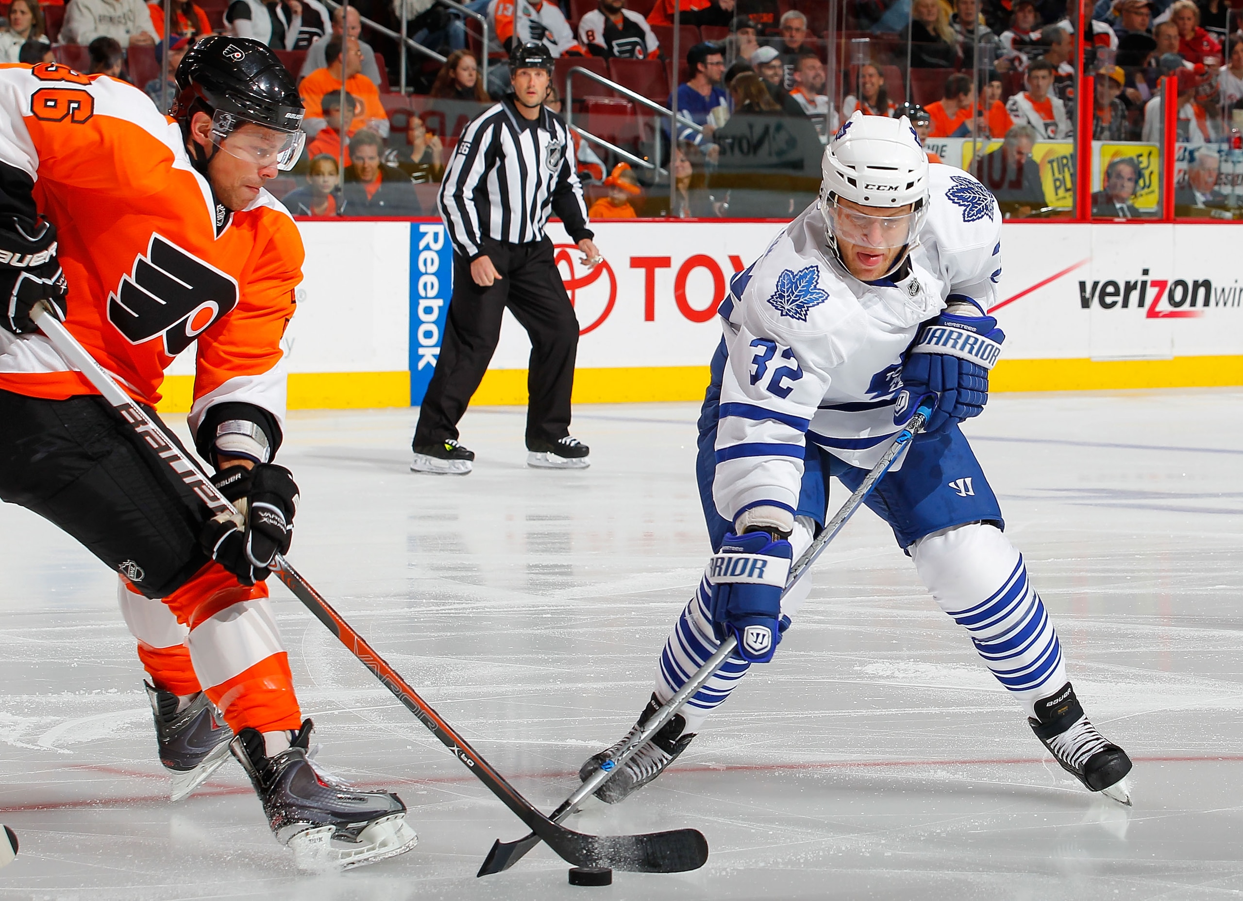 PHILADELPHIA - OCTOBER 23:  Kris Versteeg #32 of the Toronto Maple Leafs reaches for the puck as Darroll Powe #36 of the Philadelphia Flyers pulls it back in a hockey game at the Wells Fargo Center on October 23, 2010 in Philadelphia, Pennsylvania.  (Phot