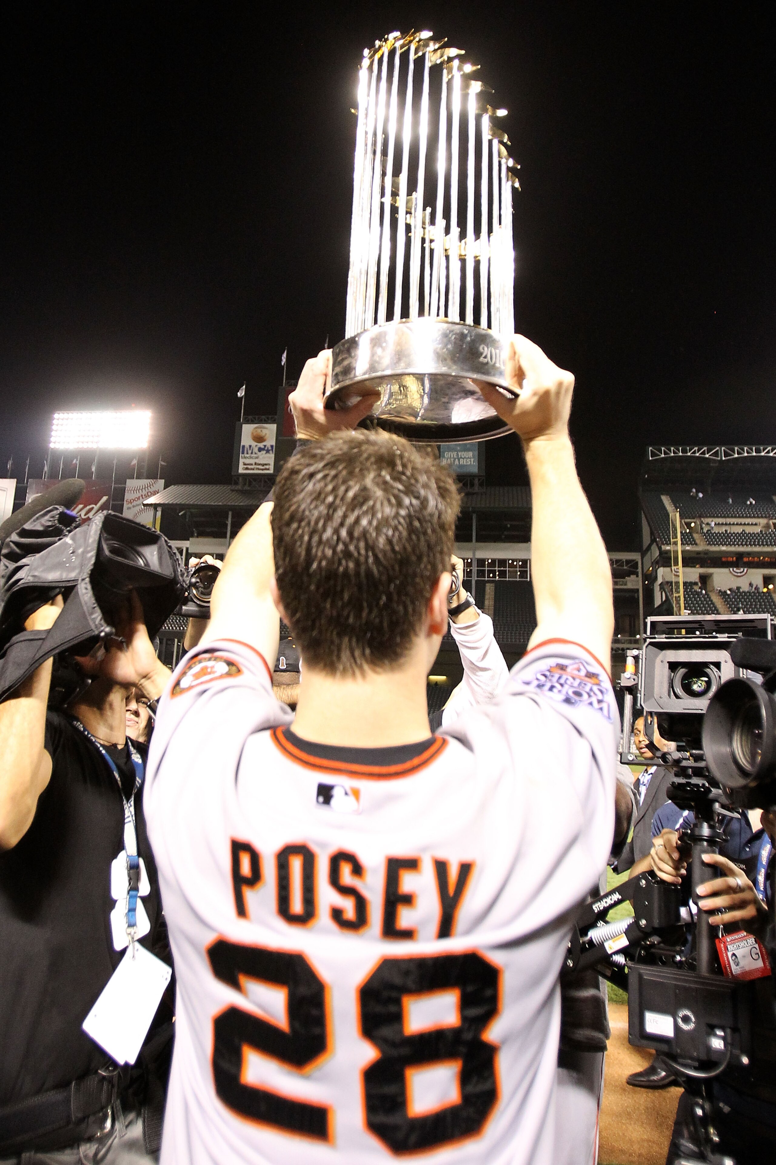 ARLINGTON, TX - NOVEMBER 01: Buster Posey #28 of the San Francisco Giants celebrates with the World Series Championship trophy after the Giants won 3-1 the Texas Rangers in Game Five of the 2010 MLB World Series at Rangers Ballpark in Arlington on Novemb ARLINGTON, TX - NOVEMBER 01: Buster Posey #28 of the San Francisco Giants celebrates with the World Series Championship trophy after the Giants won 3-1 the Texas Rangers in Game Five of the 2010 MLB World Series at Rangers Ballpark in Arlington on Novemb