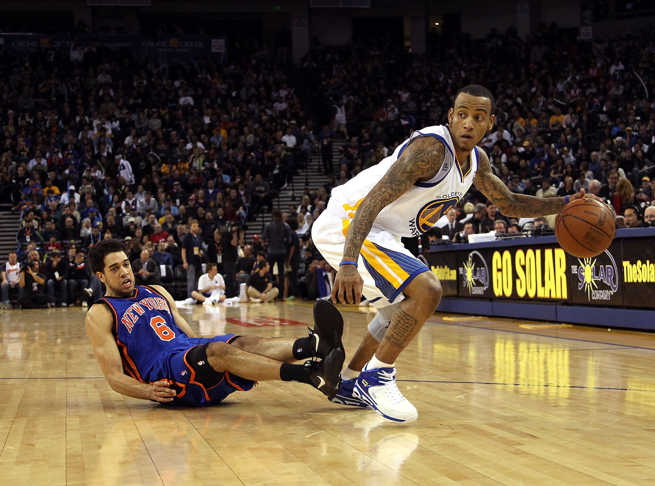 OAKLAND, CA - NOVEMBER 19:  Monta Ellis #8 of the Golden State Warriors dribbles the ball after Danillo Gallinari #8 of the New York Knicks falls down at Oracle Arena on November 19, 2010 in Oakland, California. NOTE TO USER: User expressly acknowledges a