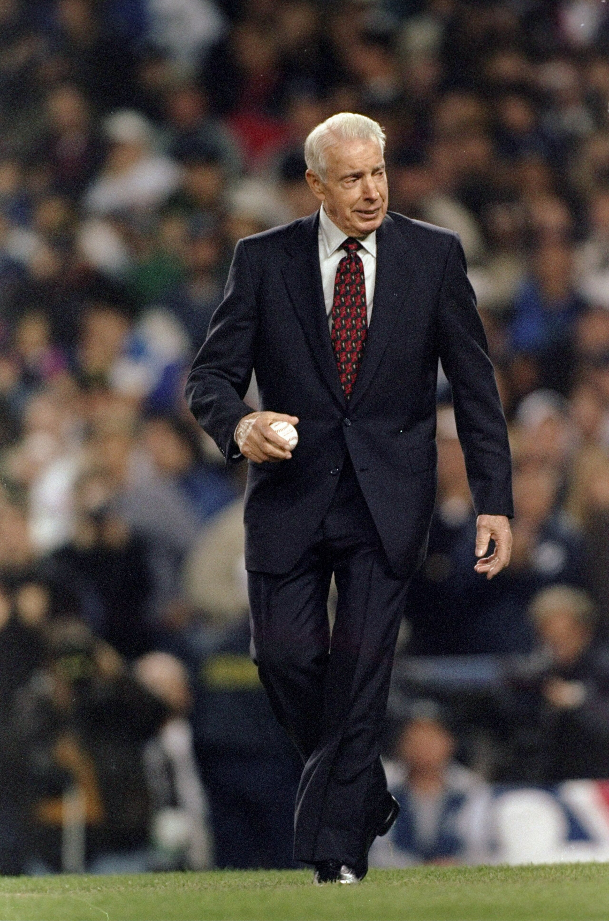 20 Oct 1996:  Baseball great Joe Dimaggio walks out to the pitchers mound to throw out the first pitch of the 1996 World Series Game One between the Atlanta Braves and the New York Yankees at Yankee Stadium in the Bronx, New York. The Braves defeated the