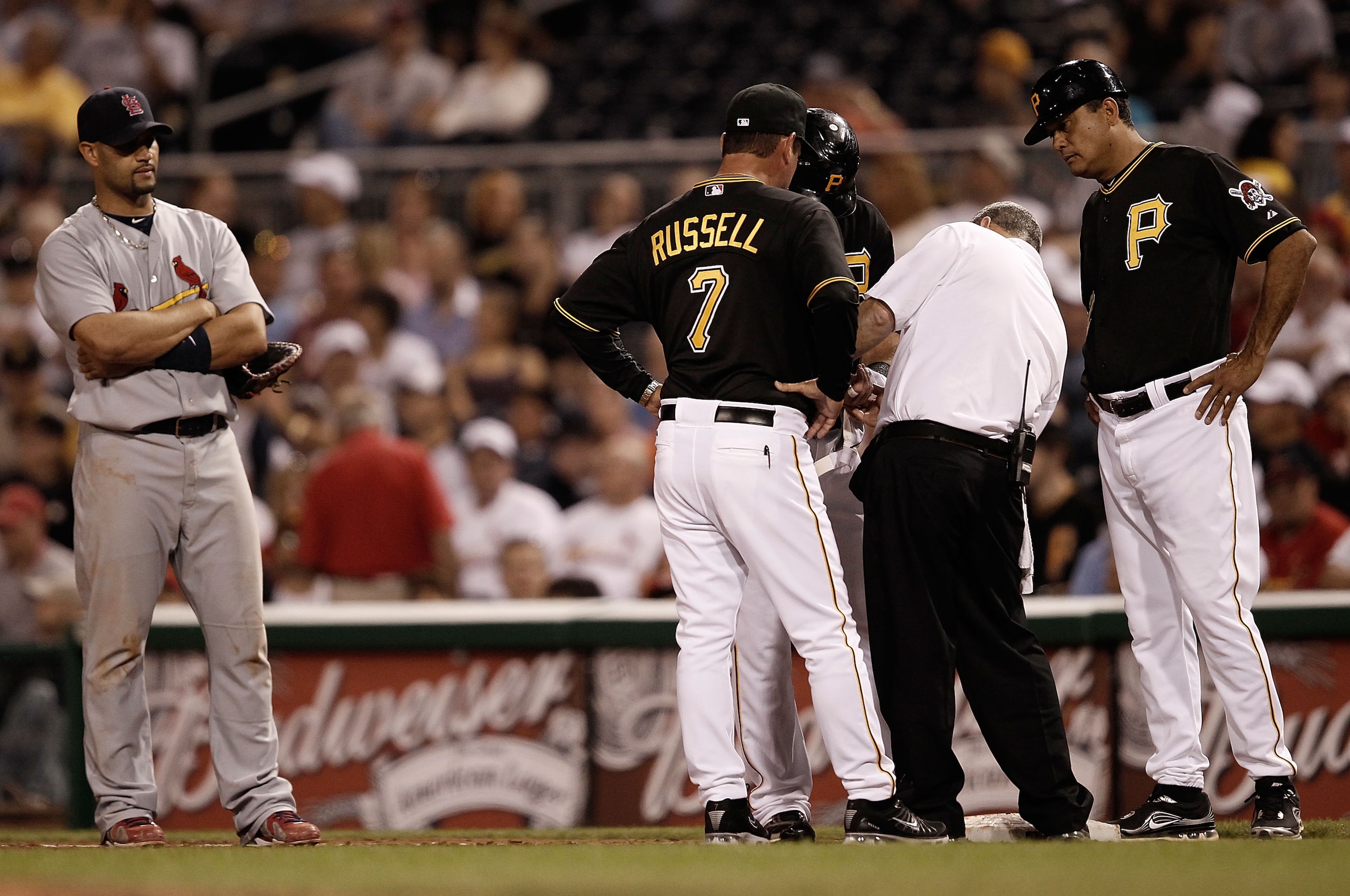 PITTSBURGH - MAY 07:  Albert Pujols #5 of the St Louis Cardinals looks on as Ryan Church #19 of the Pittsburgh Pirates is checked out by manager John Russell #7, Carlos Garcia #12, and a trainer after being hit by a pitch on the wrist during the game on M