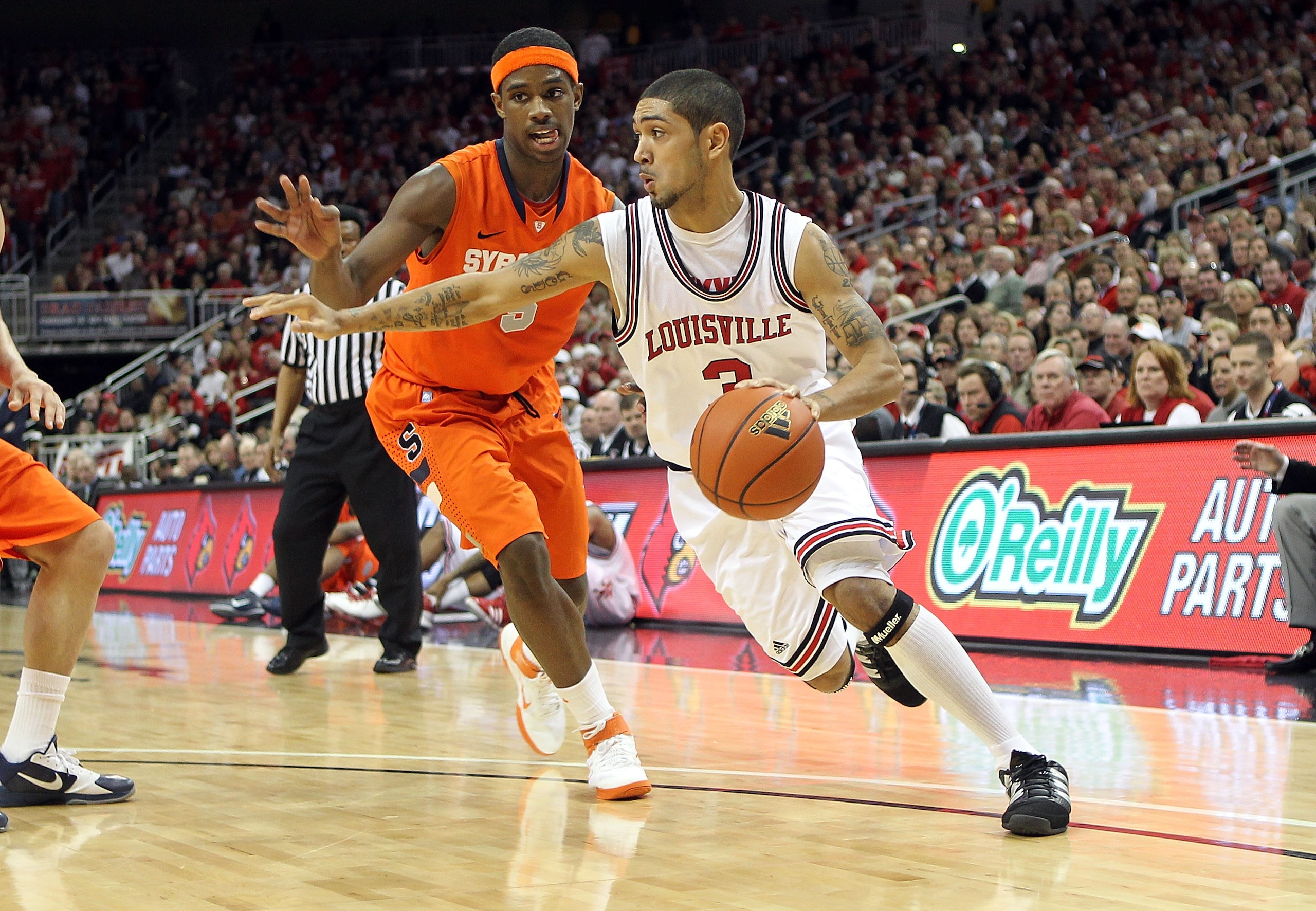 LOUISVILLE, KY - FEBRUARY 12:  Peyton Siva #3 of the Louisville Cardinals dribbles the ball while defended by C.J. Fair #5 of the Syracuse Orange during the Big East Conference game against  at the KFC Yum! Center on February 12, 2011 in Louisville, Kentu