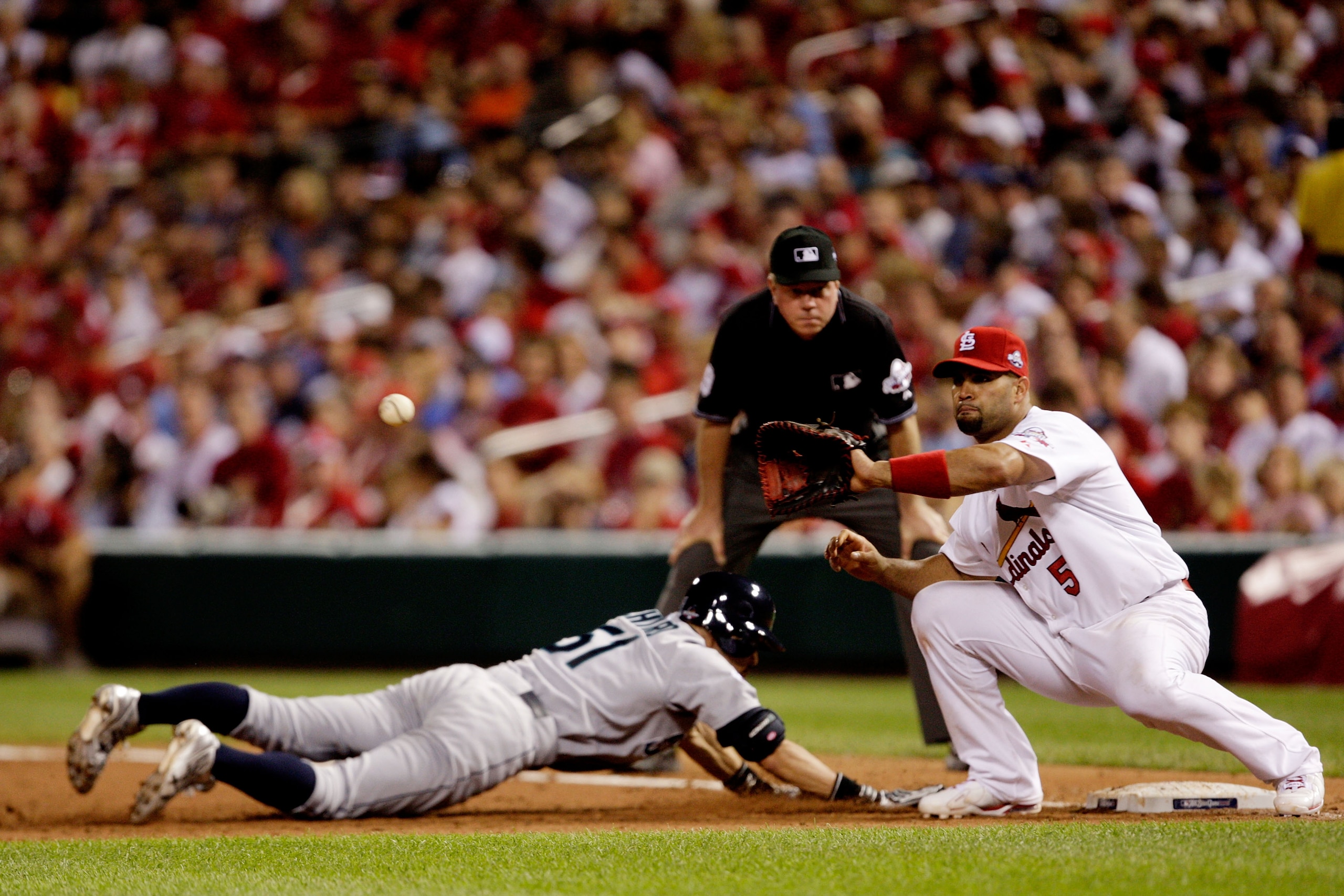 ST LOUIS, MO - JULY 14:  American League All-Star Ichiro Suzuki of the Seattle Mariners dives safely back to first base against National League All-Star Albert Pujols #5 of the St. Louis Cardinals during the 2009 MLB All-Star Game at Busch Stadium on July
