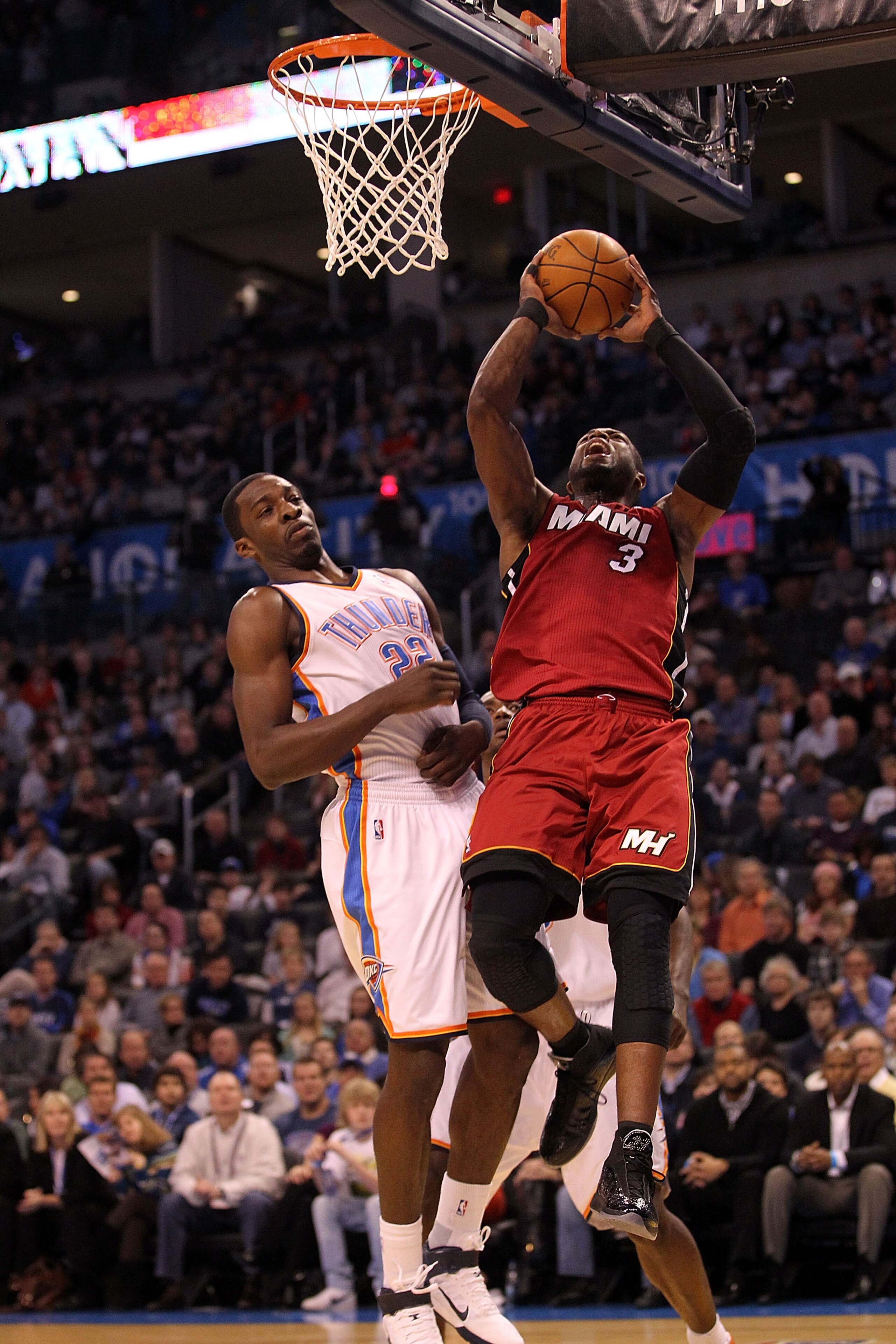 OKLAHOMA CITY, OK - JANUARY 30:  Guard Dwyane Wade #3 of the Miami Heat takes a shot against Jeff Green #22 of the Oklahoma City Thunder at Ford Center on January 30, 2011 in Oklahoma City, Oklahoma.  NOTE TO USER: User expressly acknowledges and agrees t