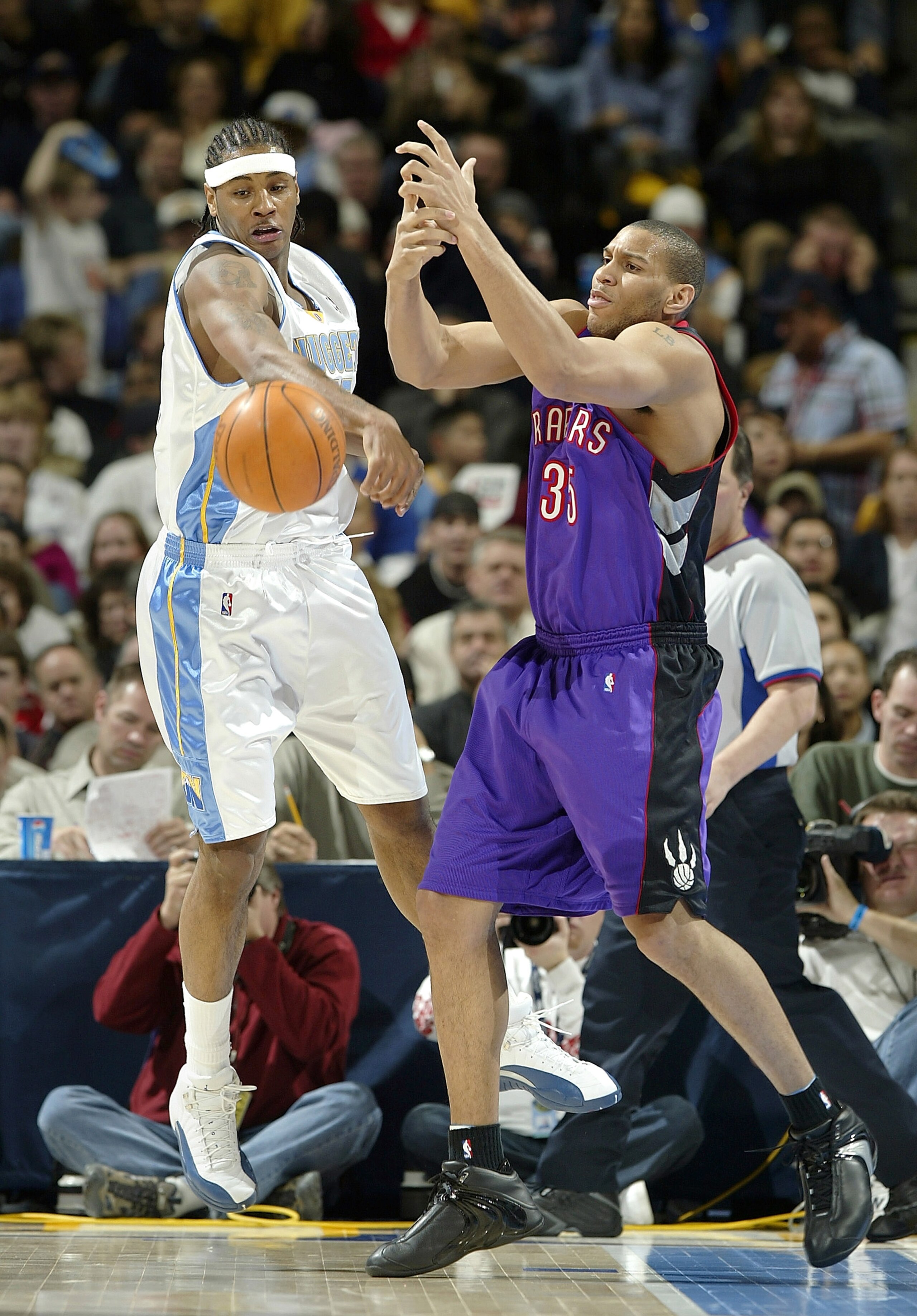 DENVER - DECEMBER 30:  Carmelo Anthony #15 of the Denver Nuggets creates a turnover against Lonny Baxter #35 of the Toronto Raptors in the first half December 30, 2003 at the Pepsi Center in Denver, Colorado.  NOTE TO USER:  User expressly acknowledges an