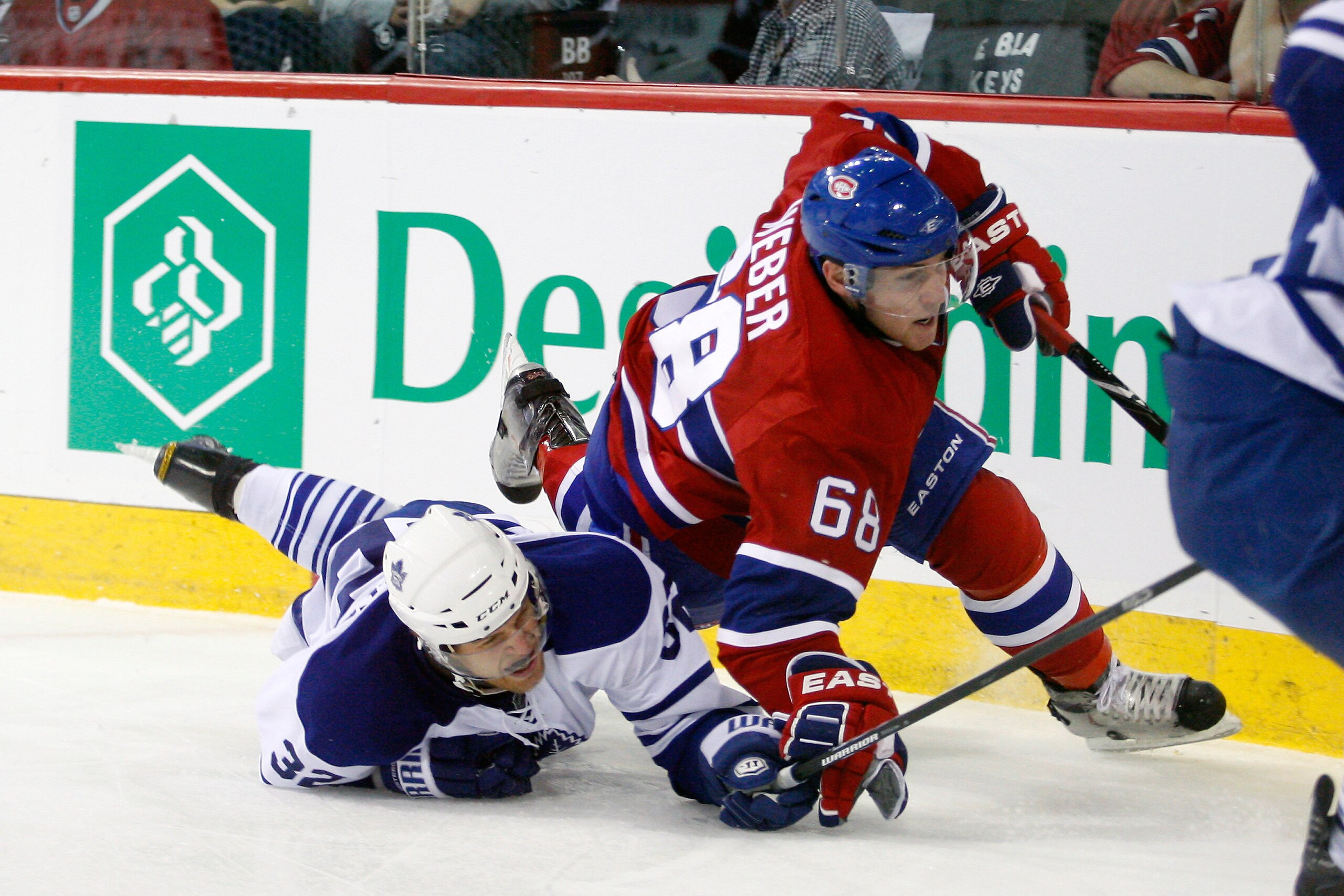 MONTREAL, CANADA - FEBRUARY 12:  Kris Versteeg #32 of the Toronto Maple Leafs and Yannick Weber #68 of the Montreal Canadiens collide during the NHL game at the Bell Centre on February 12, 2011 in Montreal, Quebec, Canada.  (Photo by Richard Wolowicz/Gett