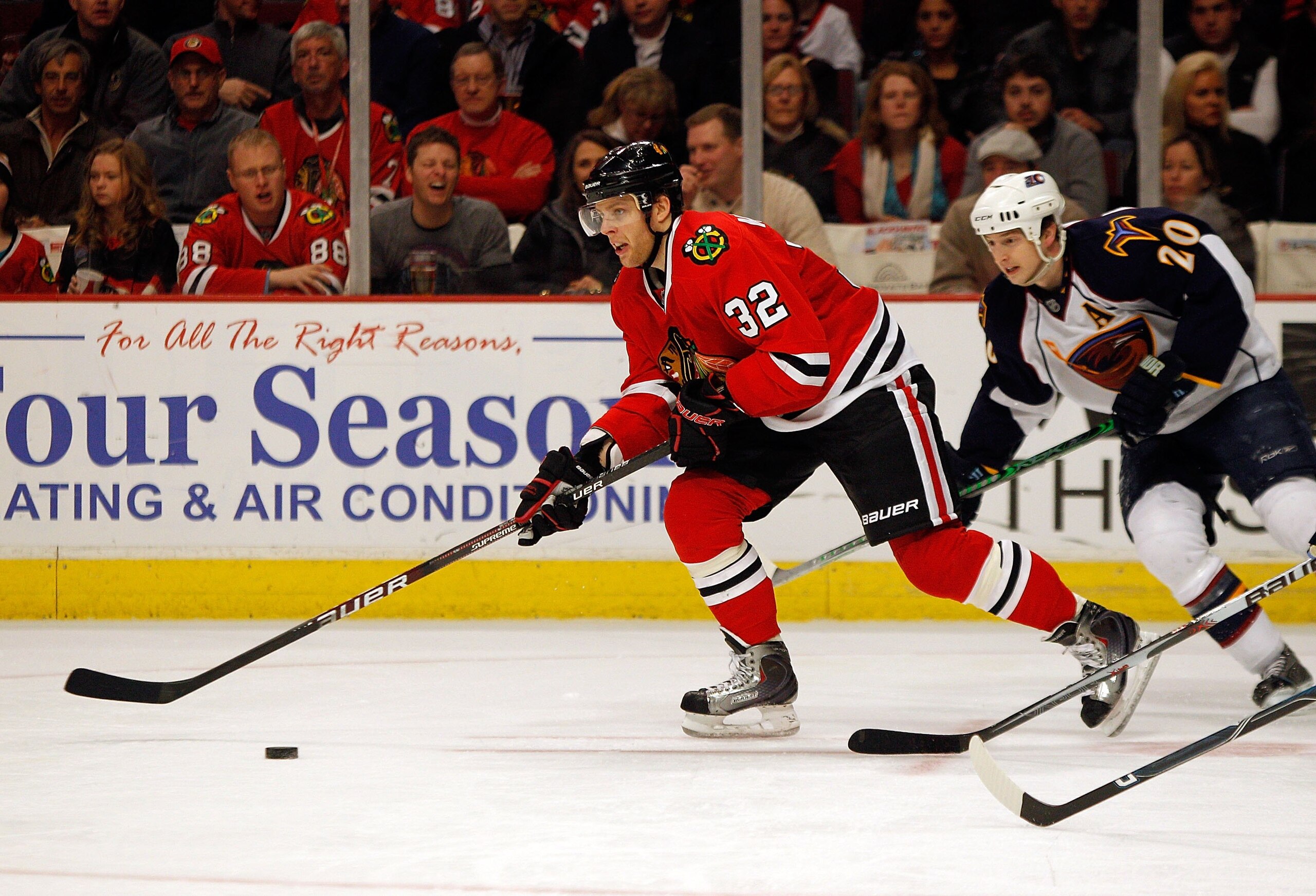 CHICAGO - FEBRUARY 13: Kris Versteeg #32 of the Chicago Blackhawks looks to pass under pressure from Colby Armstrong #20 of the Atlanta Thrashers at the United Center on February 13, 2010 in Chicago, Illinois. The Blackhawks defeated the Thrashers 5-4 in