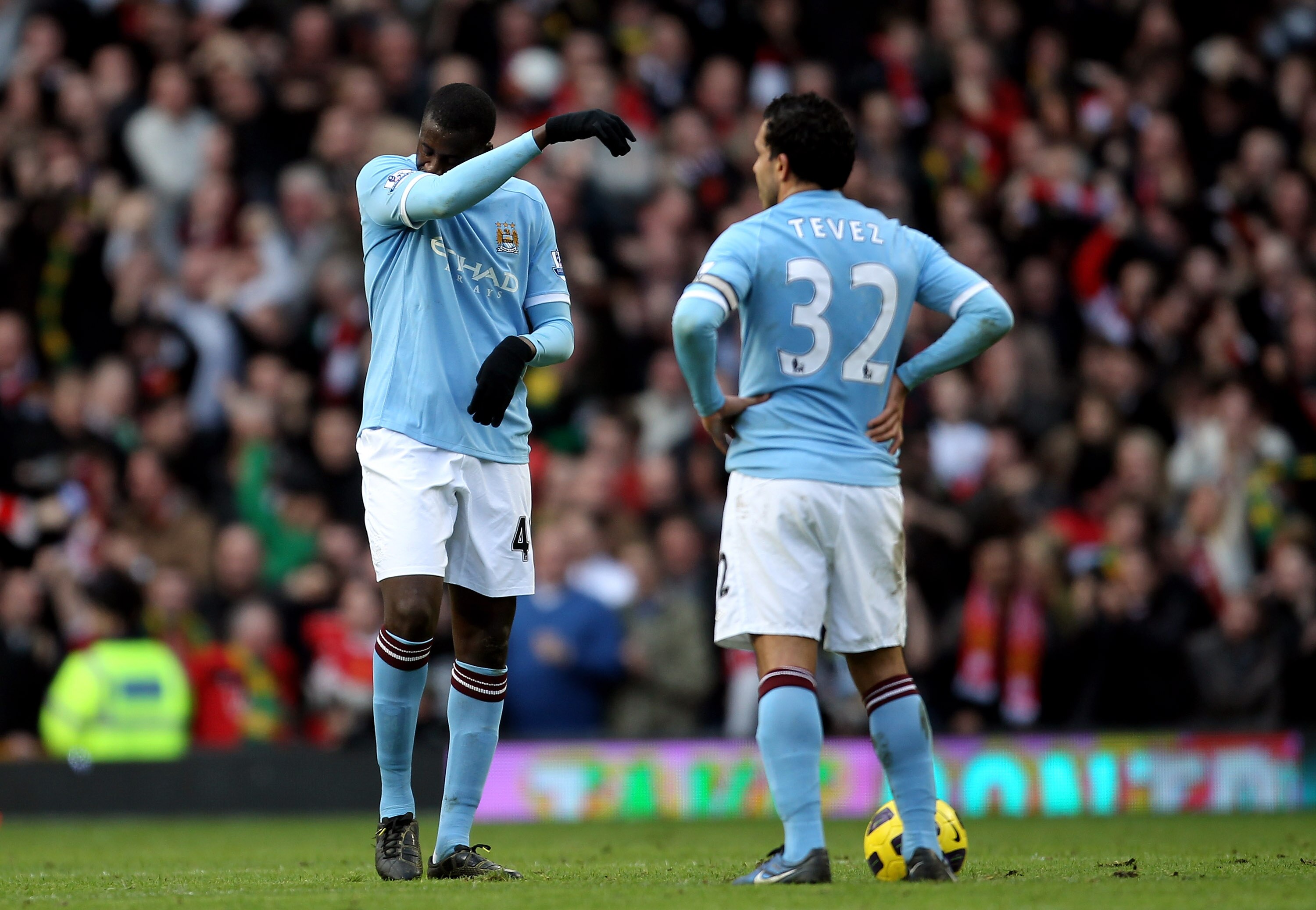 MANCHESTER, ENGLAND - FEBRUARY 12:  Yaya Toure (L) and teammate Carlos Tevez of Manchester City stand dejected after conceding a goal during the Barclays Premier League match between Manchester United and Manchester City at Old Trafford on February 12, 20