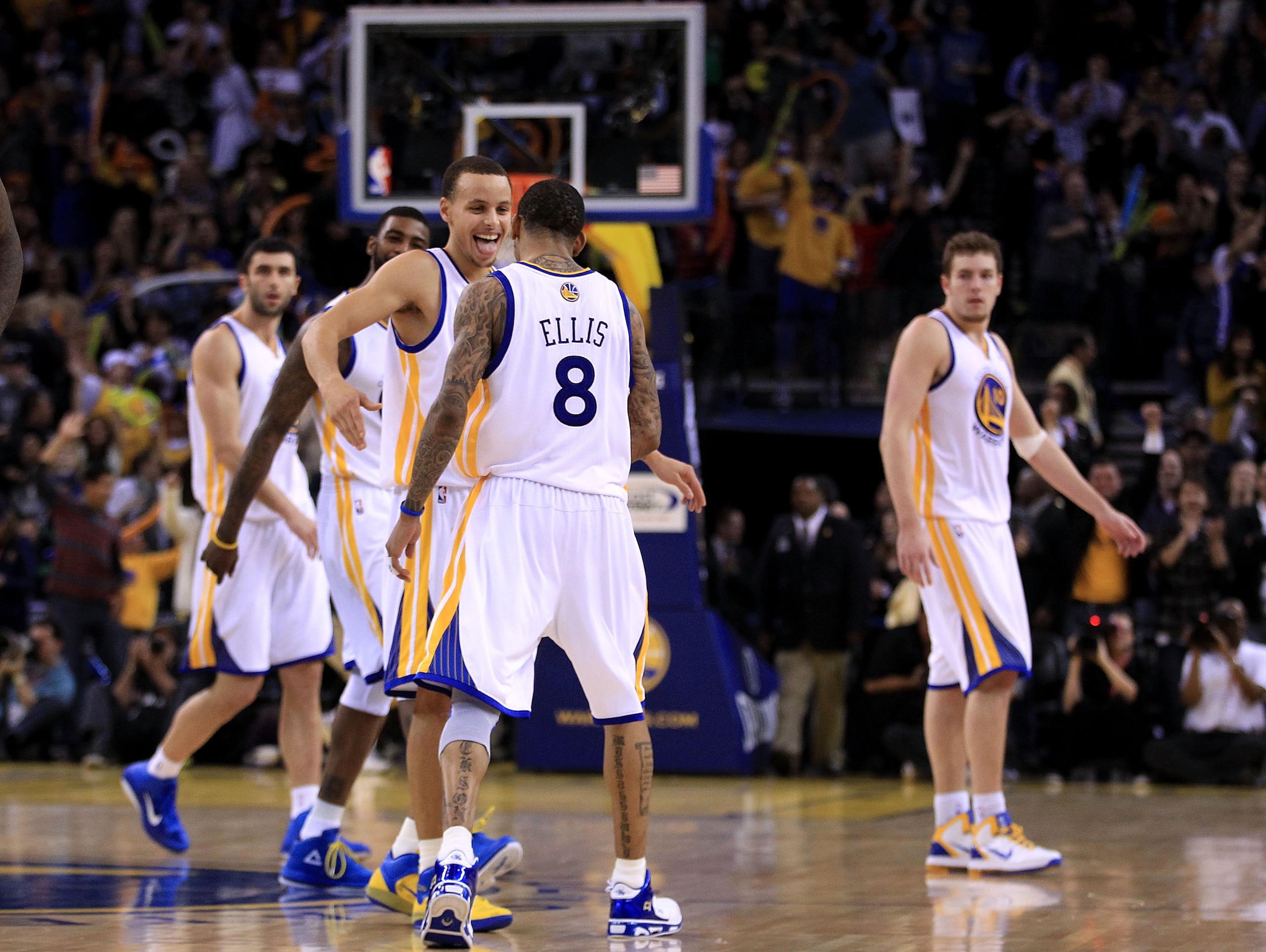 OAKLAND, CA - JANUARY 21:  Monta Ellis #8 is congratulated by Stephen Curry #30 of the Golden State Warriors after Ellis made a shot with less than a second left in regulation to send their game against the Sacramento Kings into overtime at Oracle Arena o