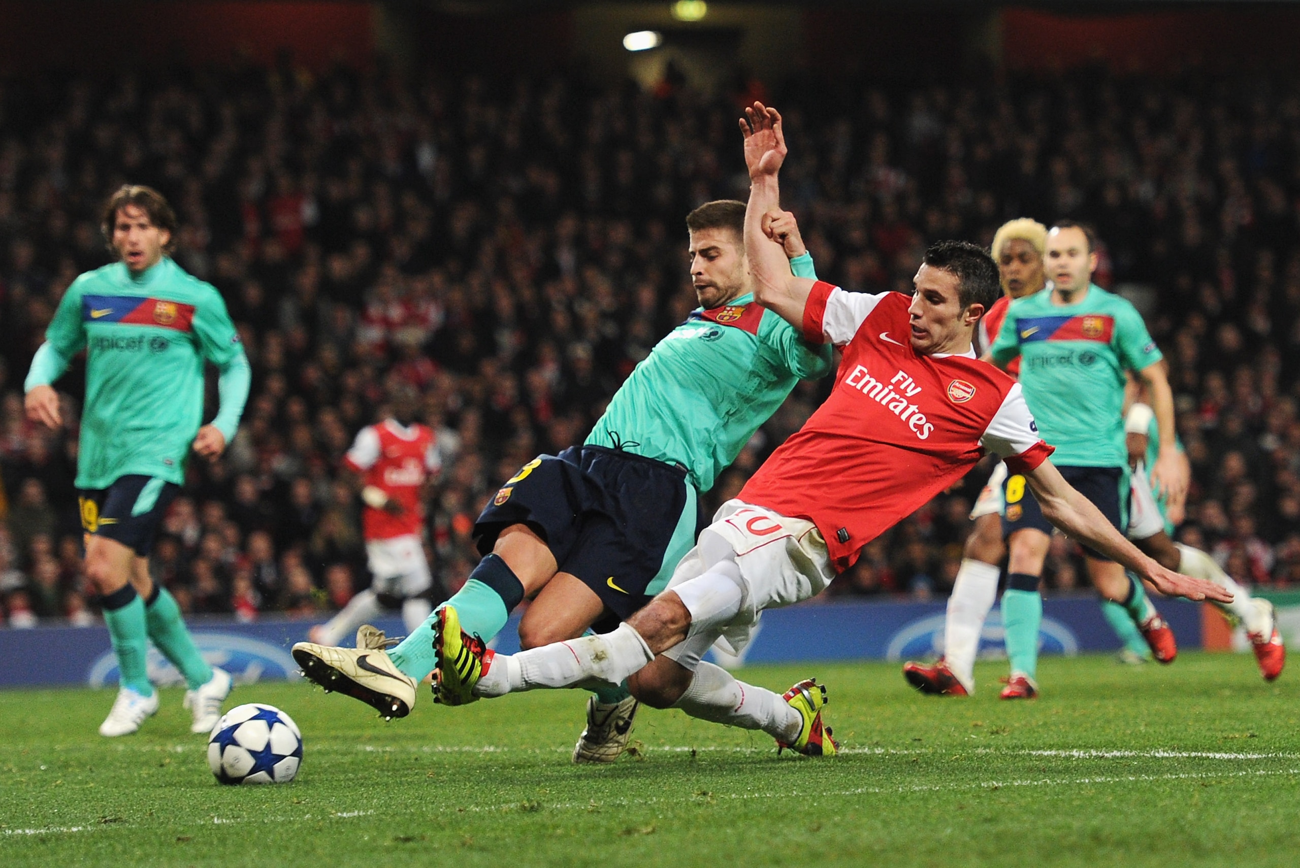 LONDON, ENGLAND - FEBRUARY 16:  Robin van Persie of Arsenal shoots at goal under a challenge by Gerard Pique of Barcelona during the UEFA Champions League round of 16 first leg match between Arsenal and Barcelona at the Emirates Stadium on February 16, 20