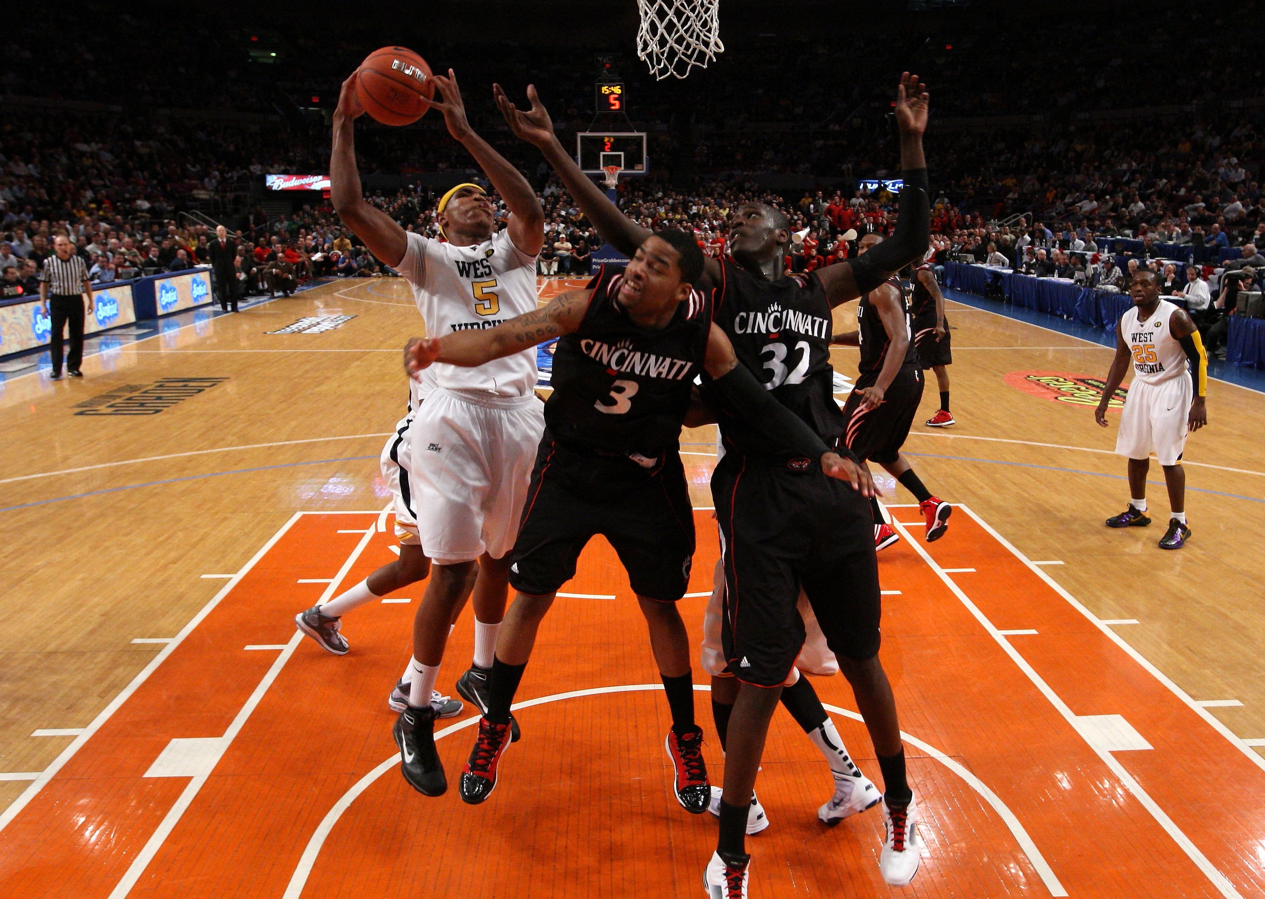 NEW YORK - MARCH 11: Kevin Jones #5 of the West Virginia Mountaineers goes to the hoop against Dion Dixon #3 and Ibrahima Thomas #32 of the Cincinnati Bearcats during the quarterfinal of the 2010 NCAA Big East Tournament at Madison Square Garden on March