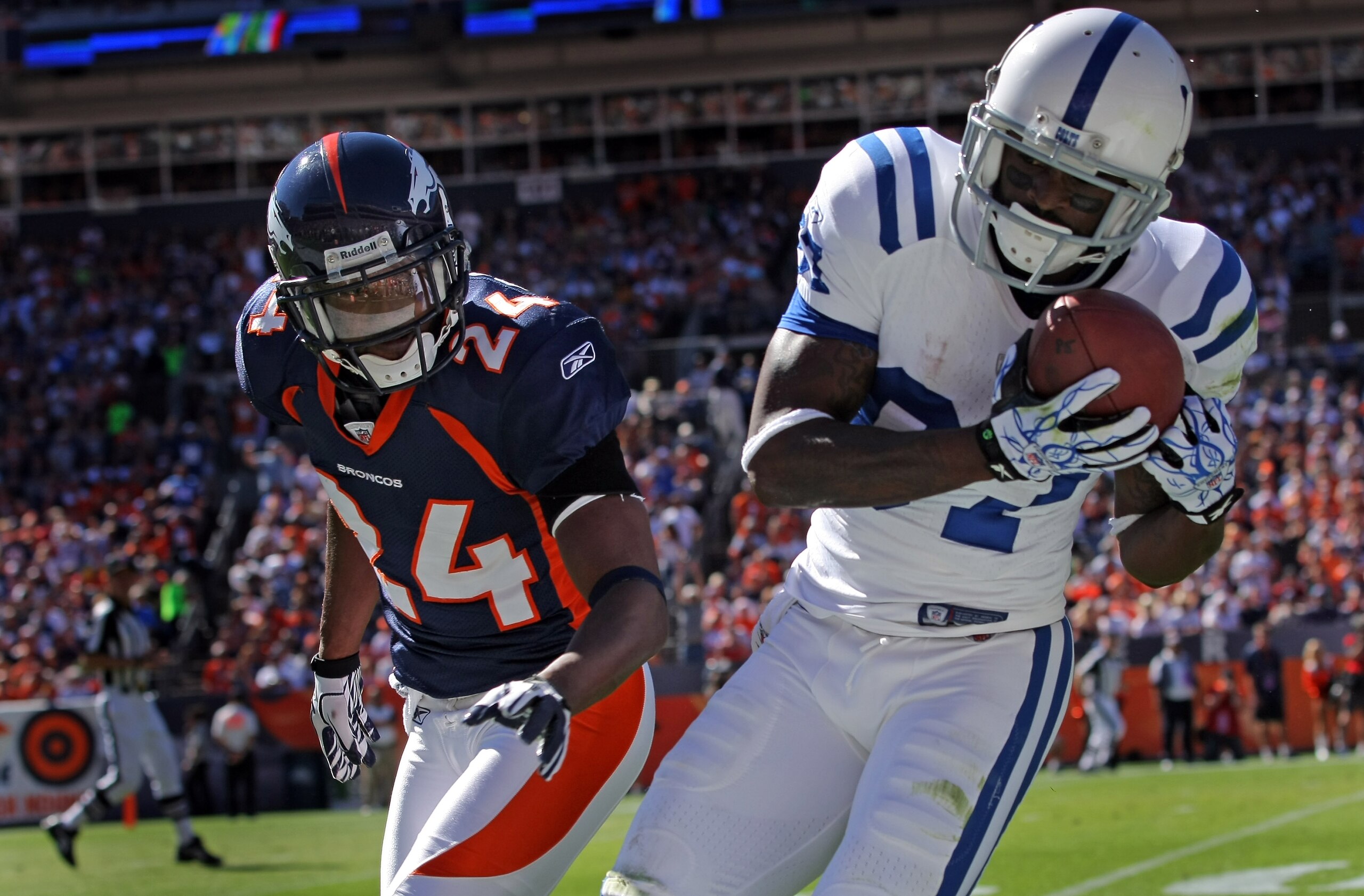 DENVER - SEPTEMBER 26:  Wide receiver Reggie Wayne #87 of the Indianapolis Colts makes a first down reception as Champ Bailey #24 of the Denver Broncos defends at INVESCO Field at Mile High on September 26, 2010 in Denver, Colorado. The Colts defeated the